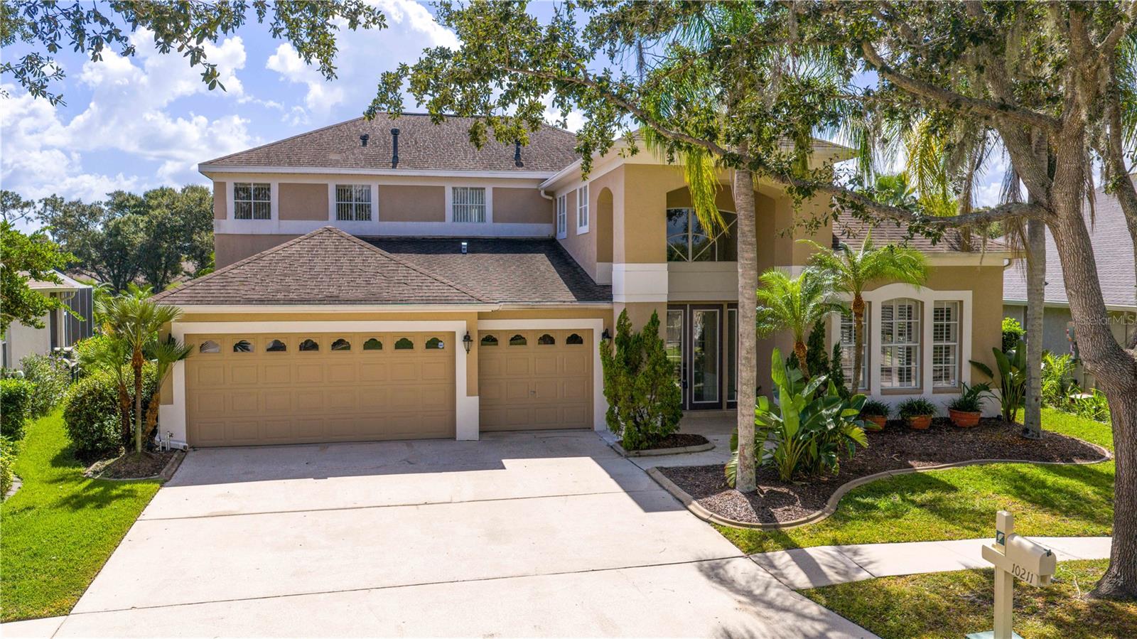 Executive home in Quail’s Landing of Arbor Greene, perfectly positioned on a waterfront lot and offering one of the best values in the community. At over 3,300 sq. ft., this is the best-priced large home in Arbor Greene. A rare find with dual master suites—one upstairs and one downstairs—this layout is ideal for multi-generational living or flexible use. The home features 4 bedrooms, 4 bathrooms, A downstairs flex room/office, an upstairs office, and a 3-car garage. Spacious living areas filled with natural light and water views.
The dramatic two-story foyer opens to a formal living room with plantation shutters and custom millwork, leading into the open-concept main living space with 12-foot sliding doors to the screened lanai. Outside, enjoy an outdoor kitchen, spa, and pavered patio overlooking the water. The kitchen is finished with solid marble countertops, a center island, double ovens, 5-burner gas range, and stainless-steel appliances. Off the kitchen, you will find a large flex room that can be used as a downstairs office, play room, or private reading room. The first-floor primary suite has floor-to-ceiling windows with water views, a soaking tub, walk-in shower, dual vanities, and large closet. Upstairs includes a second master suite with vaulted ceiling and a spacious ensuite, plus two additional bedrooms and a home office with built-in desk and cabinetry. Roof replaced in 2016.
Arbor Greene offers 24/7 manned gates, clubhouse with event space, fitness center, Olympic-sized and resort-style pools, tennis courts, pickleball courts, playgrounds, and miles of walking paths and nature trails. Conveniently located minutes from I-75 with quick access to shopping, restaurants, hospitals, USF, and downtown Tampa. This home offers both space and value in one of New Tampa’s most established communities.