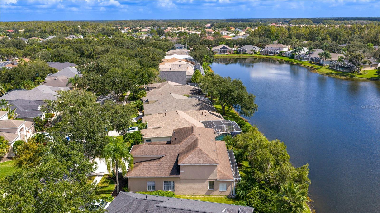 Executive home in Quail’s Landing of Arbor Greene, perfectly positioned on a waterfront lot and offering one of the best values in the community. At over 3,300 sq. ft., this is the best-priced large home in Arbor Greene. A rare find with dual master suites—one upstairs and one downstairs—this layout is ideal for multi-generational living or flexible use. The home features 4 bedrooms, 4 bathrooms, A downstairs flex room/office, an upstairs office, and a 3-car garage. Spacious living areas filled with natural light and water views.
The dramatic two-story foyer opens to a formal living room with plantation shutters and custom millwork, leading into the open-concept main living space with 12-foot sliding doors to the screened lanai. Outside, enjoy an outdoor kitchen, spa, and pavered patio overlooking the water. The kitchen is finished with solid marble countertops, a center island, double ovens, 5-burner gas range, and stainless-steel appliances. Off the kitchen, you will find a large flex room that can be used as a downstairs office, play room, or private reading room. The first-floor primary suite has floor-to-ceiling windows with water views, a soaking tub, walk-in shower, dual vanities, and large closet. Upstairs includes a second master suite with vaulted ceiling and a spacious ensuite, plus two additional bedrooms and a home office with built-in desk and cabinetry. Roof replaced in 2016.
Arbor Greene offers 24/7 manned gates, clubhouse with event space, fitness center, Olympic-sized and resort-style pools, tennis courts, pickleball courts, playgrounds, and miles of walking paths and nature trails. Conveniently located minutes from I-75 with quick access to shopping, restaurants, hospitals, USF, and downtown Tampa. This home offers both space and value in one of New Tampa’s most established communities.