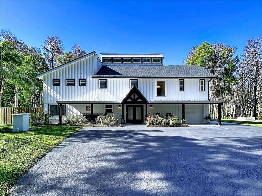 Private executive lakefront estate, located on a peninsula giving you waterfront access to lake frontage as well as the serene peacefulness of the canal. This property is being offered below appraised value—move-in ready and priced to sell. This rare and unique property offers exceptional privacy, surrounded by water and set on 3.21 secluded acres in the heart of Land O’ Lakes. The home features over 3,300 square feet of living space, with 5 bedrooms, 3 bathrooms, and a spacious office, perfectly blending luxury with a peaceful, private setting. Enjoy direct frontage on private King Lake, a 125+ acre ski lake ideal for boating, fishing, jet skiing, and all water sports—with no public boat ramp for added exclusivity. Positioned on a peninsula, the property boasts over 1,000 feet of combined lake and canal frontage, offering expansive open water views along with the calm serenity of canal living. The home has been thoughtfully updated and includes two full kitchens (upstairs and downstairs), two living areas, two fireplaces, two laundry rooms, a large kitchen island, walk-in pantry, and wine fridge—making it ideal for multi-generational living or entertaining. Outdoor living is just as impressive, with two covered porches (upper and lower) connected by a spiral staircase and both assessable from inside of the home, both overlooking the water and capturing stunning sunset views. Additional features include two private docks, a newly built fire pit, paved walkways, a gated private drive, and a welcoming front porch perfect for relaxing evenings. A truly rare opportunity to own a private, one-of-a-kind lakefront peninsula property with unmatched water frontage and versatility. Seller is open to selling the house furnished.