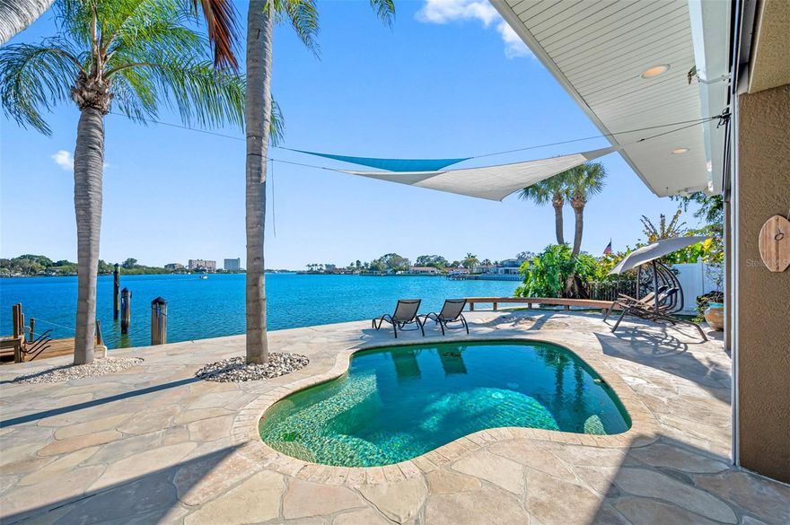 Looking for a boating home to hold your 60' yacht or fishing boat, or just an unbelievable open water view that will meet all your expectations? The inside of this opulent home is top of the line perfection, a must see, it is immaculate! The over sized kitchen, remodeled with an immense granite island has tons of storage, seating, and heated tile floor. Watch dolphins play out your mile long Southern water view, the sunsets are beautiful, on a clear day you can see the Don CeSar. The new composite dock has a 13k boat lift with a 12' beam capability that will hold a 35' sport fish, two 30 amp ship/shore power stations allow to park your live aboard yacht, and cable for TV and media is at the dock. 2 wave runner lifts w/remotes, and a 8'x16' moveable floating platform adds tremendous convenience. The 19'x13' "swim jetted" dipping pool is ideal for exercise or just relaxing. There is a seven person hot tub under the pergola, outdoor hot shower, 2 outdoor projector hook ups, and sound. 116' seawall built in 2008 with a 36" cap, it's your private sidewalk on the water. A completely electric enclosable patio, storage shed, 2 separate AC systems, home and dock wired for security cameras. Electric blinds in MB & FR, master bath luxury design with skylight over shower, the whole home has been completely remodeled, and has hurricane glass windows and doors, you simply must see and hear all the outstanding features this home has to offer.