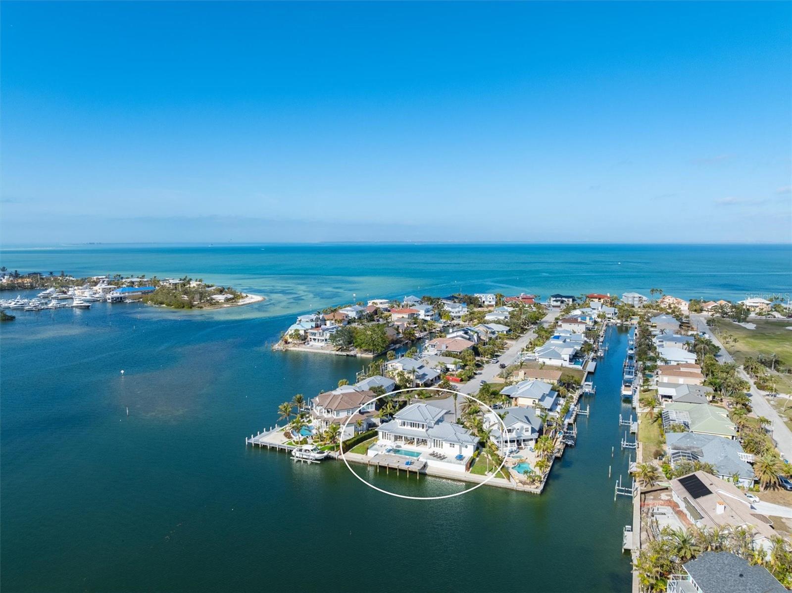 Stunning, luxury waterfront residence nestled in the prestigious Key Royale neighborhood of Holmes Beach on Anna Maria Island. This modern, all block, 3,290-square-foot home offers 5 spacious bedrooms and 4.5 luxurious bathrooms. Situated on the very end of a quiet cul-de-sac, the home features direct access to the serene waters of Bimini Bay, making it a paradise for boating enthusiasts and those who appreciate tranquil water views. Designed by Beacon Designs, built by Mason Martin, Interior design by HSH, every detail has been thoughtfully considered with the finest finishes throughout. The open concept living area seamlessly blends contemporary design with coastal elegance, featuring abundant natural light, gorgeous white wood beams, and exquisite views of Bimini Bay. The gourmet kitchen is equipped with top-of-the-line appliances, marble countertops and a custom built-in bench and large dining table and chairs from Arhaus. Each bedroom is designed for comfort and privacy, with four of them having their own ensuite bathroom and patio or balcony access! Bonus living area upstairs with a sofa and TV for the kids to enjoy movie night! The primary bedroom ensuite features 2 French doors that open up onto the patio overlooking Bimini Bay allowing for breathtaking sunsets every night; the perfect retreat at the end of the day. The bathroom has dual sinks, large walk-in shower, and walk-in closets with a built-in seated bench. Extensive usable outdoor space for sun loungers, games, entertainment, and family fun! Take a dip in the heated pool with tanning ledge/sun shelf area and enjoy the 160 feet of waterfront views, large rectangular dock, covered relaxing seating area for lounging and dining, this home is ideal for entertaining and having friends and family over! Outdoor shower, lush landscaping, plenty of storage- you name it! You don’t have to worry that you will run out of parking, you can easily fit 4 cars in the driveway and there is a 2-car garage. This home has it all and even sits 15 feet above sea level giving its new owner peace of mind. Enjoy the convenience of the proximity to The Key Royale Golf Club, as well as Bimini Bay, Tampa Bay, and the Gulf of Mexico. An idyllic residence for boaters and golfers, this home offers the perfect blend of elegance and relaxation making it a perfect year-round or second home retreat. Residents can also enjoy access to swimming, tennis, pickle ball and social events at the clubhouse as part of the North Point Community HOA within the Key Royale community. Come see for yourself today!