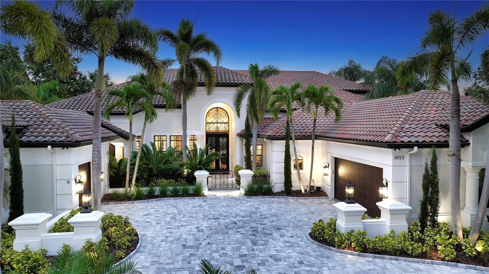 Exquisite, custom Arthur Rutenberg home rivals the best of the best in that Lakewood Ranch! This Zen like residence boast 8,514 square feet, 6600 of which is air conditioned, is truly an experience with 5 generous size bedrooms, 4 of which are ensuite, a first floor state-of-the-art gym, a second floor climate controlled wine room with iron door, two koi ponds that flank the east and west sides of the home, extraordinary finishes throughout including quartz, marble, limestone, travertine and more. The gourmet kitchen is open and airy featuring new wood cabinetry, hidden pantry closet, Miele appliances, double refrigerator/freezer, including natural gas cooktop, waterfall quartz countertop, spectacular new lighting throughout and wood butcher block bar seating! This home is sun filled with transom windows above the sliding doors, allowing the natural light to spill into every room. All five bathrooms have been transformed with state-of-the-art commodes, under counter lighting, and refined features and finishes. Upon entrance through the double Cantera Iron doors, you will be transported and experience a feeling of calm and serenity. From the handsome engineered wood floors to the 14-foot ceilings, every inch of this home has been thoughtfully remodeled with the most unique materials and selections. The primary suite located on the first floor of the west wing, offers a sitting area overlooking the newly resurfaced and retiled saltwater pool. Window blinds are controlled by remote control with new Sonos throughout! HVACS and tankless hot water heaters are new! Garage floor is epoxy paint and has built-in storage units. This home has a whole house generator! Primary closets are generous with built in cabinetry for efficiency and organization. Primary bath is one of a kind with free standing tub, dual sinks, shower with two heads, state of the art commode and decorator lighting. Travel up the staircase to the media room, wine room, fifth bedroom with huge walk-in closet and access to fully remodeled bathroom with walk-in shower. The view on this masterpiece is like no other view in Lakewood Ranch Country Club. Relax on the second floor terrace overlooking the beautiful pond and private Legacy Golf Course with mesmerizing skies! The pool and outdoor living space is an oasis of luxury and refinement with beautiful pool with sun shelf and infinity edge spa, panoramic pool screen, travertine decking, wood ceilings, summer kitchen, outdoor shower, pool bath, pool closet and two televisions! Visit 6923 Westchester Circle where form and function meet luxury.