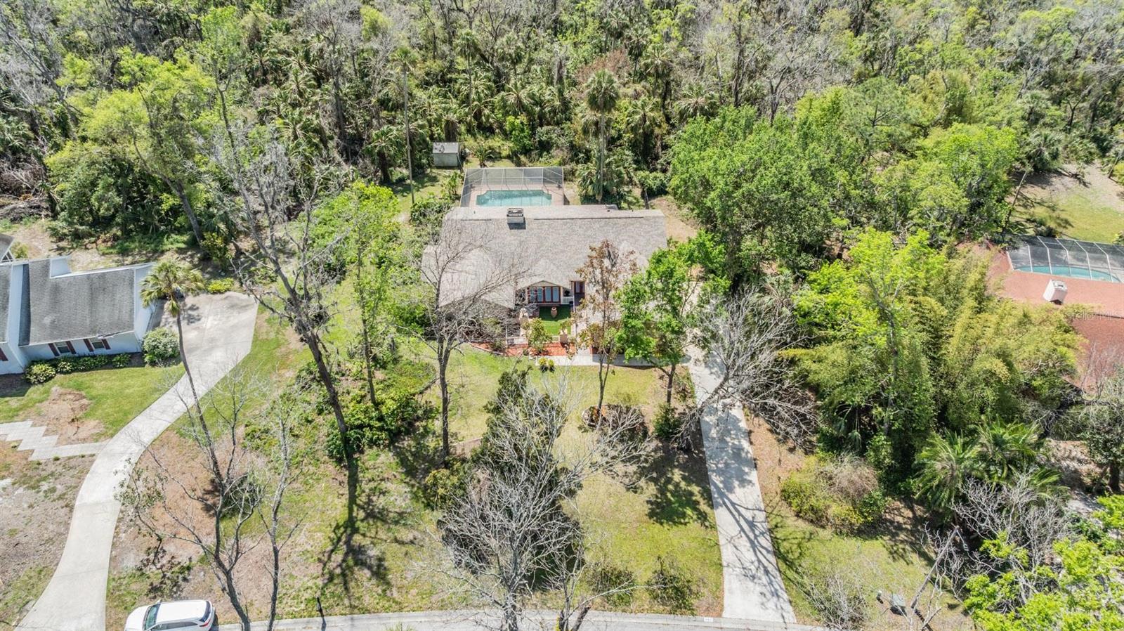 One or more photo(s) has been virtually staged. Video tour: https://youtu.be/MioMCLDNy-w?si=fpUPZ2hnCytDiqvw If you’re looking for a home that feels more private and secluded yet still in a great neighborhood this is it. This elegant property is surrounded by lush landscaping on a conservation lot with a wooded view! The garage has been converted into a 4th bedroom with a full bathroom next to it as well. This home features 3 more bedrooms and 3 more full bathrooms. Nestled on a secluded 2.37 acre lot in the desirable Indian Hills community you’ll enjoy peace and quiet on a close-end street with no through traffic. Boasting 3,100 sq ft this home is great for entertaining with a flowing open floor plan. The spacious living room includes a brick-front fireplace and a skylight to create a warm and inviting atmosphere. Wall-sized sliders in the living room, kitchen, and primary bedroom open directly to the stunning screened-in lanai, seamlessly connecting indoor and outdoor living. The open kitchen is a chef’s dream, featuring granite countertops, bright cabinetry, a breakfast bar, and sleek dark stainless steel appliances. Each of the spacious bedrooms are well designed. While the primary bedroom offers a walk-through closet and a spa-like ensuite bathroom. Complete with a dual-sink vanity, walk-in shower, extra cabinet space and a large soaking tub. The second bedroom conveniently has its own private deck and private bathroom. Out back, relax on the pavered pool deck or take a dip in the sparkling heated swimming pool. All nicely enclosed within the screened lanai. With two AC units, you’ll be comfortable inside even during those Florida summers. Conveniently located near shopping, dining and major roadways. This exceptional home is sure to impress! Schedule your private tour today.