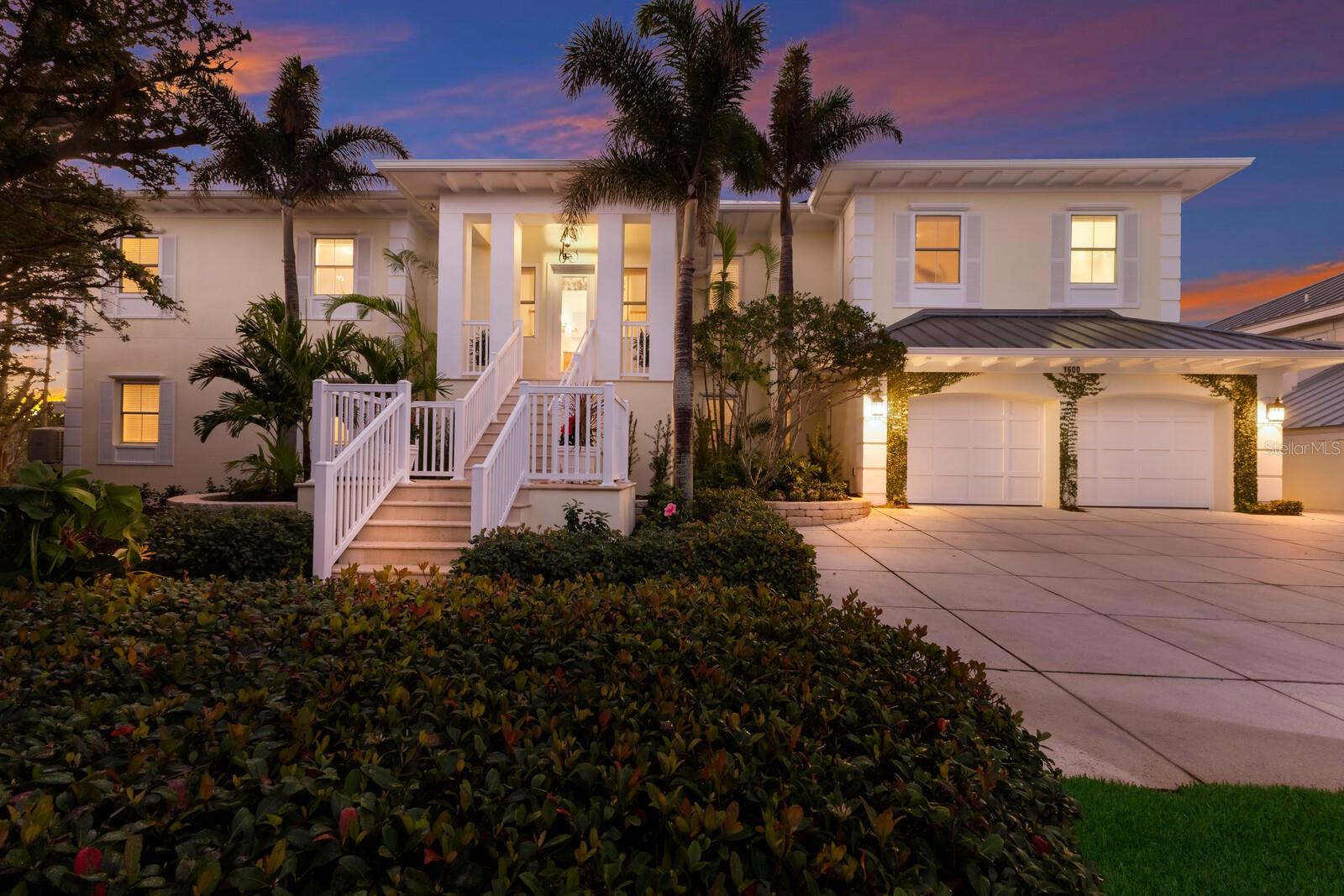 This exceptional waterfront property on a large tip lot boasts breathtaking views of Charlotte Harbor, The Gasparilla Inn Golf Course, and the surrounding natural landscape. With 170 feet of frontage, it provides deep-water dockage with a 50' dock and boat lift. Built in 2011, the home’s main floor showcases a spacious living room with a fireplace and adjacent dining area. Sliding doors lead from the living room to a spectacular sunroom, where floor-to-ceiling windows frame stunning water and golf course views, creating a breathtaking backdrop for everyday living.
The open-concept kitchen is equipped with high-end appliances, including a Sub-Zero refrigerator, double ovens, induction cooktop, and separate ice maker, all complemented by a beautiful granite island and countertops. Off the kitchen is a spectacular family room leading to a grilling patio. Noteworthy millwork, including custom door trim and crown moldings, enhances the home’s luxurious feel.
The primary suite, overlooking the waterway, includes a small office and a spacious spa-like bathroom featuring dual vanities, two closets, and two water closets. There is also a flexible bonus room perfect for a den, office, or workout room. Ideal for family and guests, the lower level boasts four en-suite bedrooms along with a shared coffee bar and family room. Beautiful wood floors, impact-resistant windows and doors, and superior construction quality round out this thoughtfully designed home. A convenient elevator provides easy access to all floors.
The expansive outdoor living space is a true highlight, with a spacious covered patio offering ample seating for relaxing or entertaining while enjoying serene views. A large heated pool offers the ultimate Florida lifestyle experience, and rear southern exposure ensures optimal sunlight throughout the day. A grassy area, swaying palm trees, and steps leading to a deck with a boat lift complete this tropical outdoor retreat.
Additional highlights include plenty of storage space and a two-car garage with a separate golf cart entrance. Savor both sunrise and sunset views from this exquisite home, located within the private, gated community of Boca Grande Isles. Just a short distance from the historic village of Boca Grande’s, charming shops, restaurants, and historic buildings, this home is a true gem.