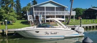 Waters Edge is offered as a turn key canal home on Little Gasparilla Island which is boat access only. This home is one of few on the island with 60 ft of private dock space in one of the only two canals. Home has open floor plan with water views from the kitchen, dining and living room. Screened upper deck is accessible by 3 french doors enlarging the space even more especially when entertaining. The bay front porch offers spectacular sunrise views. Downstairs deck area is great for relaxing with family, fishing off dock or cleaning your boat and simply living island life. There's a large outdoor shower that everyone enjoys after a day at the beach. Waters Edge is currently a VRBO rental with documented rental income and has many repeat vacationers. Other features include: standing seam roof, composite seawall, six year old Florida regulated septic, three year old A/C system, one year water heater and a minute walk to some of the most amazing sunsets you'll ever witness.