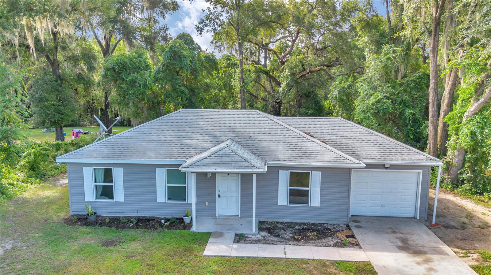Charming 3-bedroom, 2-bath home built in 2021, just 10 minutes from Beautiful Lake Weir. This property features a 1-car garage and an oversized backyard with no neighbors behind or on one side, offering added privacy and space. Surrounded by large, mature trees, the home provides a peaceful, nature-inspired setting while still being close to all the amenities of town—an ideal retreat for anyone seeking comfort and quiet.
