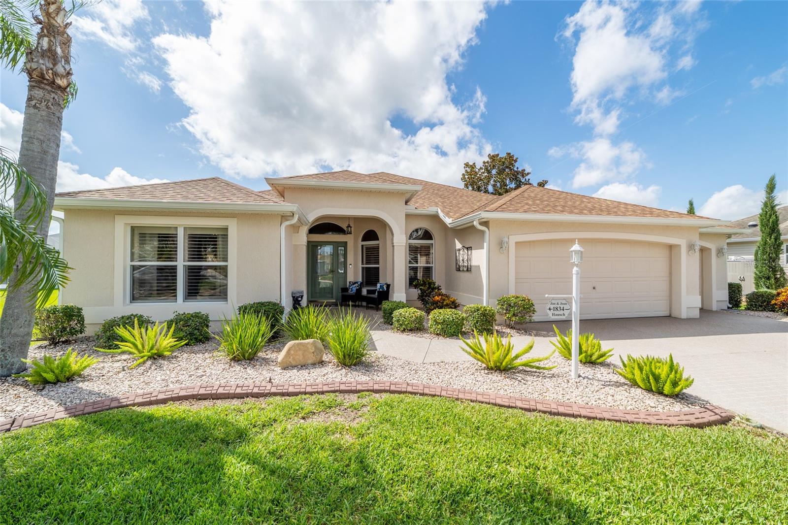 Welcome to this beautifully customized 3-bedroom, 2-bath (One with out closet) Designer Gardenia located in the highly sought-after Village of Winifred, just minutes from Lake Sumter Landing and offering a rare peek-a-boo view of Arnold Palmer’s Championship Laurel Valley Golf Course — right from your living room! This home impresses from the moment you arrive, with a custom paver driveway, mature landscaping, and a quiet cul-de-sac setting.Expanded Garage + GOLF CART GARAGE, with epoxy flooring, pull-down attic stairs, and storage shelving. Step inside and you’ll find luxury vinyl plank flooring throughout the main living areas, ceramic tile in the wet spaces, and an open, airy layout featuring vaulted ceilings and PLANTATION SHUTTERS throughout. The heart of the home is the expanded living space, highlighted by a custom double sliding glass door that frames stunning views of your SALTWATER POOL, screened in a recently refurbished birdcage. Relax in the shade under the custom screen shade with TV hookup, or fire up the grill in the covered outdoor BBQ area—perfectly designed for year-round entertaining. The kitchen is a chef’s dream with CORIAN countertops, a tasteful tiled backsplash, NATURAL GAS RANGE, newer appliances, and a charming breakfast nook. INSIDE LAUNDRY with a utility sink. Another special touch, the LANAI IS ENCLOSED under heat and air adding extra living space and features a custom bar with a second access to the outdoor living space for convenience, creating an ideal space for hosting friends and family. The primary suite is a true retreat, offering his and her walk-in closets, a dual vanity, and an upgraded tiled walk-in shower. The split floor plan provides privacy for guests, with one room featuring a custom Murphy bed and built-in desk with storage, and the other cozy and spacious and filled with natural light. Additional highlights include:
2023 Roof Replacement
Updated HVAC & Hot Water Heater
No Bond!
Water Filtration System
This exceptional property has been loved and maintained; checks every box for both comfort and style—don’t miss your chance to own a piece of paradise in The Villages!