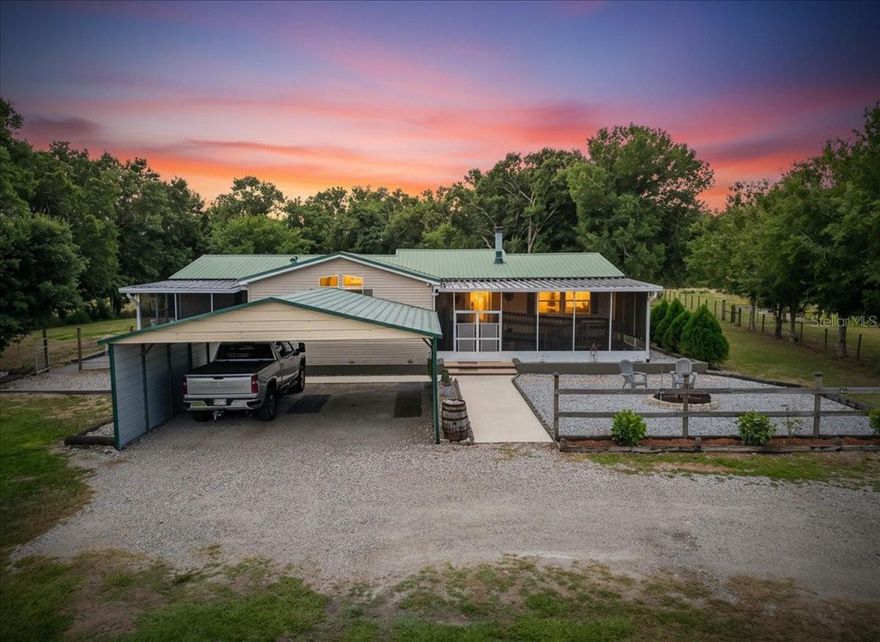 If you’ve been looking for space, freedom, and a little bit of country living without giving up comfort, this one is worth a look. Located in Wimauma, this 4-bedroom, 2-bath mobile home sits on 5 fully fenced acres, giving you plenty of room to spread out, bring your animals, or just enjoy the privacy. Inside, the home feels warm and inviting with luxury vinyl flooring running through the main living areas and a wood-burning fireplace that makes the space feel like home the moment you walk in. The layout offers a good balance of open living space and separate bedrooms, making it practical for everyday life. Outside is where this property really shines. In addition to the 2-car carport, there’s a massive 26x36 garage outbuilding—perfect for a workshop, storage, or hobby space. It even includes an air-conditioned room that works great as an office, studio, or flex space depending on your needs. The property is zoned AR, so you have the flexibility to bring farm animals, start a small homestead, or simply enjoy wide open space with no HOA restrictions telling you what you can and can’t do. Whether you’re looking for room to grow, a place to work from home, or just a quieter lifestyle, this property offers a lot of possibilities. Updates include W/H June 2022, HVAC Unit August 2022 Well pump June 2024.