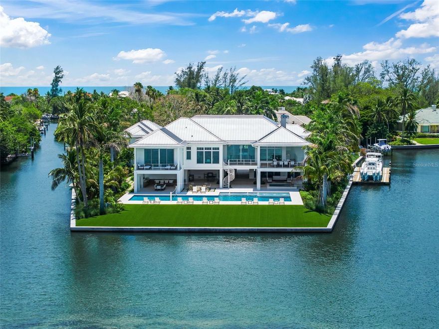 Welcome to your private, gated estate on Longboat Key, where coastal luxury meets effortless sophistication. Boasting over 730 feet of water frontage, this stunning property offers panoramic views of Whitney Bayou and Harris Canal and provides the ultimate waterfront lifestyle. With 9,243 square feet of air-conditioned living space and a total of 21,562 square feet on over an acre of pristine land, this estate is a masterpiece of design and craftsmanship.

Designed in the timeless British West Indies style, this home showcases vaulted ceilings, extensive trim detailing, white oak floors throughout, and two fireplaces, creating an ambiance of elegance and warmth. The expansive covered patios and porches invite you to embrace the serenity of waterfront living, while the heated pool and an impressive 13' x 13' hot tub serve as the ultimate retreats. A custom outdoor fire pit, two outdoor kitchens and indoor and outdoor pool tables elevate the entertainment experience.

For boating enthusiasts, this estate is unrivaled, featuring four low-profile boat lifts.  The largest lift accommodating vessels up to 30,000 pounds, the second lift is suitable for a vessel up to 20,000 pounds, and the third and fourth lift each have a 5,000 pound capacity, ideal for jet skis, kayaks, and paddle boards. Located just 10 minutes from the Gulf of America by boat and 5 minutes to Shore and Mar Vista restaurants, this is the perfect haven for life on the water.

Inside, the Wolf Sub-Zero appliances provide top-tier performance in a gourmet kitchen built for culinary excellence. A Control4 smart home system offers seamless automation throughout, while HVAC-equipped garages ensure comfort year-round. The multiple garages can accommodate up to 9 cars, and the massive driveway can host 20+ vehicles.

The residence boasts six spacious bedrooms, each with an en-suite bathroom, plus an additional full bath, and two half baths. Designed for both productivity and leisure, the home features his and hers offices, a media/theater room, a fully equipped gym, sauna, golf simulator, tackle garage, and a workshop. A private guest suite with a separate entrance includes a kitchenette, dining room, living room, bedroom, and bathroom, offering a luxurious retreat for visitors.

With two state-of-the-art elevators, expansive landscaping, and a maintenance-free turf yard, this estate blends modern convenience with natural beauty.

Ideally located near pristine beaches, world-class shopping, and gourmet dining, this estate is the epitome of waterfront elegance and exclusivity. Experience the pinnacle of coastal living--this is truly paradise found.