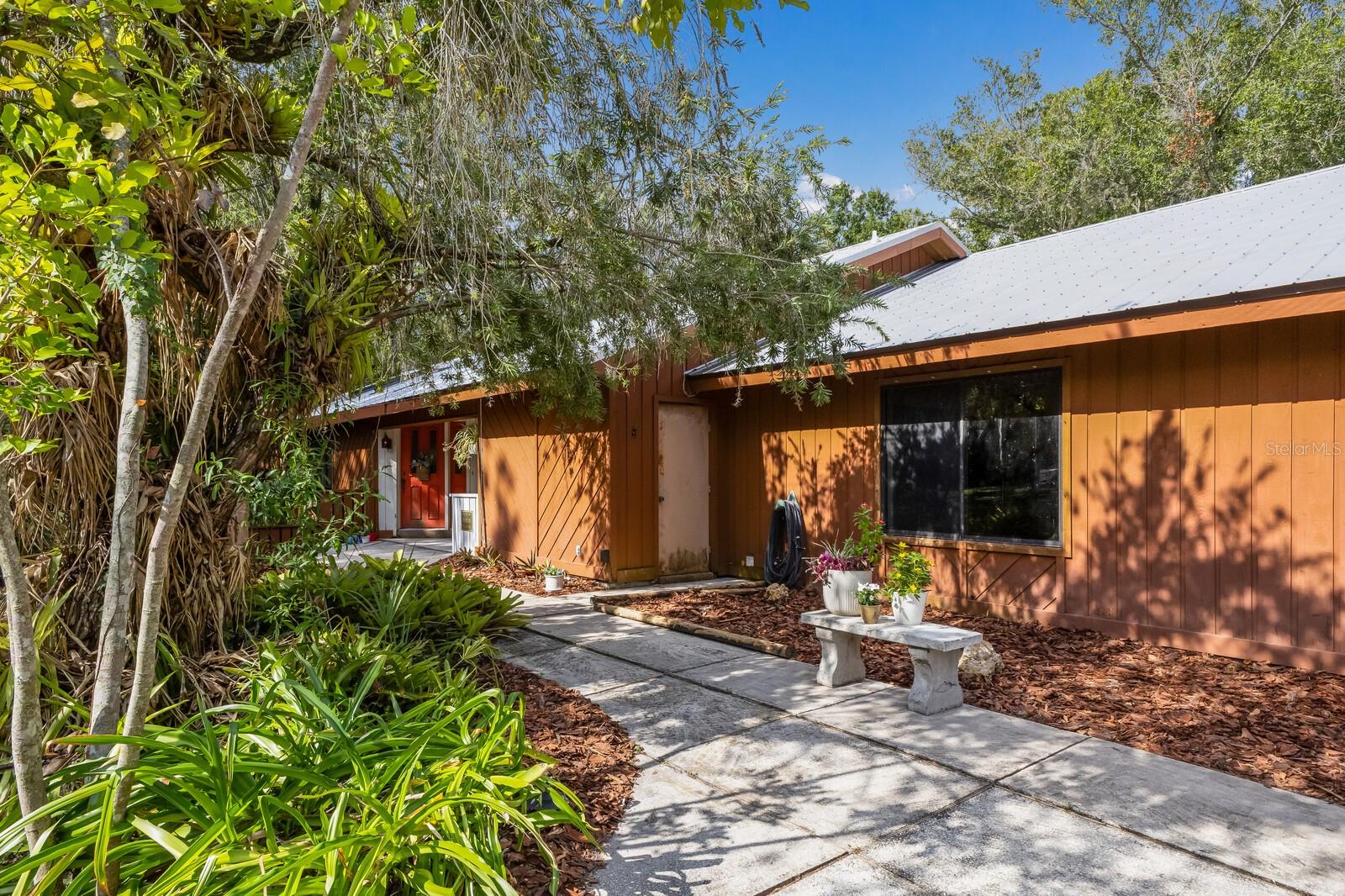 Are you a VISIONARY? Have you ever watched HGTV and thought, I could do that! ? If so, pack up your tape measure and come on down to see this true gem waiting for your personal touch. Tucked away in Braden Pines, one of Lakewood Ranch’s most sought-after neighborhoods, this "diamond in the rough" offers endless potential for the buyer or investor. Here’s your chance to secure a highly sought-after 1.24 Acre property in the heart of Lakewood Ranch—with NO CDD fees and NO HOA. Bring your Boats, your RV and your Chickens! Your New Metal Roof was installed in 2015. This spacious 4-bedroom, 2.5-bath, 80’s modern home is being sold As-Is. The treasure boasts over 3,224 sq ft of flexible space with distinctive architectural lines, vaulted ceilings, and an open floor plan just waiting to be transformed. Nestled among mature trees with ample privacy and space to expand, this home sits in one of the fastest-growing and most desirable areas in all of Florida and is loaded with potential for a high-ROI renovation, rental, or resale. The home boasts a unique open floor plan with high ceilings, and an open floor plan. With some imagination, and cosmetic updates, this property might easily be worth $900,000+ There is huge Loft area over the Carport which might possibly be converted into a home office, business or an area for Multi-Generational living space. Make it your dream estate or a valuable addition to your portfolio. There is plenty of space for outdoor living or even a small ADU/guest house. Opportunities like this don’t come around often, so bring your vision and transform this solid structure into your personalized paradise in Lakewood Ranch. This home offers an exceptional opportunity to create your dream residence in a truly unbeatable location. Surrounded by beautifully maintained homes and just minutes from A rated schools, fine dining, shopping and major thoroughfares, the setting alone speaks to lasting value and lifestyle appeal. While the home currently reflects a more original condition, it provides a solid foundation for transformation. The soaring tongue and groove wood-clad ceilings overlook generous room sizes, boasting an open floor plan and architectural features which offer the perfect canvas for a luxury renovation. Whether you are a visionary buyer or investor looking to capitalize on the neighborhood's appeal, this property is ripe with potential. Opportunities like this are extremely rare, especially in Braden Pines. With a special restoration/refurbishment, this home could become one of the best! Gulf Coast Beaches are within minutes as well as downtown Sarasota's Arts and Cultural Districts. Call today for your private showing!