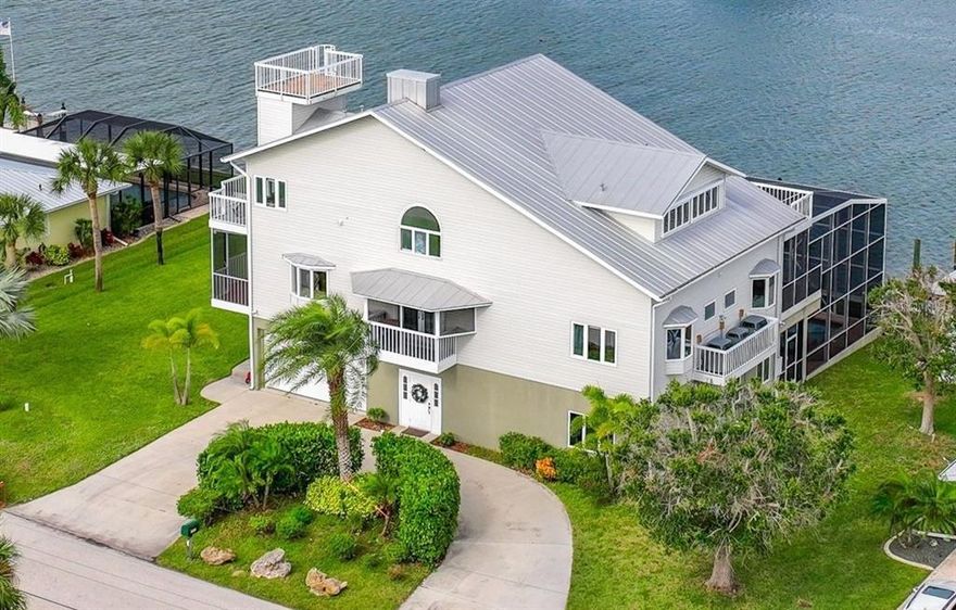 Welcome to this exceptional custom-built home directly on Lemon Bay with quick access to the Gulf of Mexico. This 3-story home features elegant wood flooring and trim throughout, beautiful tile, hurricane shutters and windows, an elevator and separate chair-lift, 5 bedrooms, 5 baths, a library, an office, an exceptionally large kitchen, large dining room, along with a double living room and separate family room and that’s just the inside! Starting at the top of the home; the amazing third floor features an extra-large Owner’s Suite with en suite bath, washer/dryer hook-up, walk-in closet, elevator access and two walls of floor to ceiling windows facing west for a spectacular view from bed. Also on the third floor is the stunning, teak shelved library with French doors out to the 3rd floor balcony overlooking Lemon Bay and the pool. From the balcony there is access to the 4th floor crow’s nest landing.  Also on the third floor is a separate office with a secret room. The second floor features an expansive kitchen including a sub-zero refrigerator, separate ice machine, convection oven, walk-in pantry, custom Red-Jay cabinets, a large island with sink, cooktop and breakfast bar, and elevator and balcony access. The large dining room is also surrounded by floor to ceiling windows with gorgeous views of the water. The double living room has a balcony on the front side of the home (facing south), a 2-story Keystone quarried fireplace with additional French doors to the second-floor balcony (facing north).  Also on this floor is a guest bath and two bedroom suites each with their own bath. When entering the home on the 1st floor, you are greeted by a large family room with pine wood ceilings and a view of the pool and Lemon Bay! There are also two bedrooms and a large bathroom with a steam shower and laundry room. The large French doors in the family room open to the large lanai featuring a heated 10x45ft pool and built-in hot tub with the most stunning views around and all while being enclosed in a 2-story pool cage! There are also 6 boat docks with the outside two docks having sailboat depth water, there is a separate boathouse and a 130 linear foot seawall. This magnificent home is also located on a cul-de-sac, has a circular drive, irrigation by well, and is built on 24 bridge pilings. There are three a/c units, three water heaters and two electrical panels for complete control over your environment. The homeowner is the original owner/builder of this beautiful home and is including a Home Warranty for your peace of mind. Room Feature: Linen Closet In Bath (Primary Bedroom).