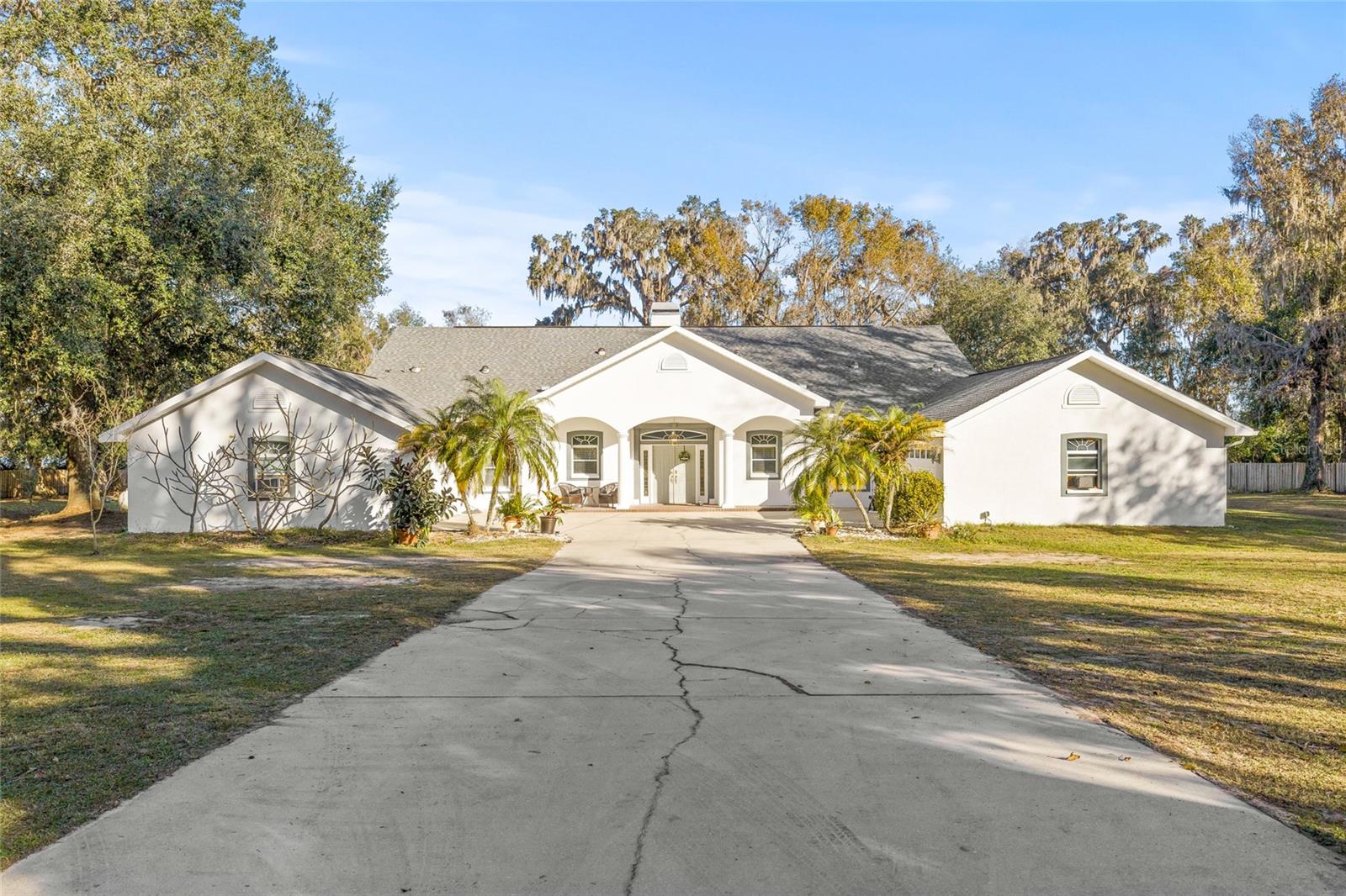 Welcome home to 8 acres of cozy seclusion. This stunning, expansive property offers unparalleled versatility. Designed with dual kitchens on each side, this home is ideal for large families or could be used as a venue for hosting beautiful events. Boasting a luxurious mother-in-law suite it's also perfect for multi-generational living. This unique layout would be an amazing investment opportunity for long term or vacation rentals with potentially 3 separate living spaces! You can relax while enjoying serene views from your backyard dock with Lake Moody set a comfortable distance away, knowing that this home has beautifully prevailed through the Florida weather and has no history of flood damage. Nestled in burgeoning Dade City on a quaint and peaceful road, yet still only 7 minutes away from I-75 offering easy access to major cities! This place has it all-even NO HOAs! Don't miss out on this unique opportunity to own a little piece of paradise. Schedule a tour!
