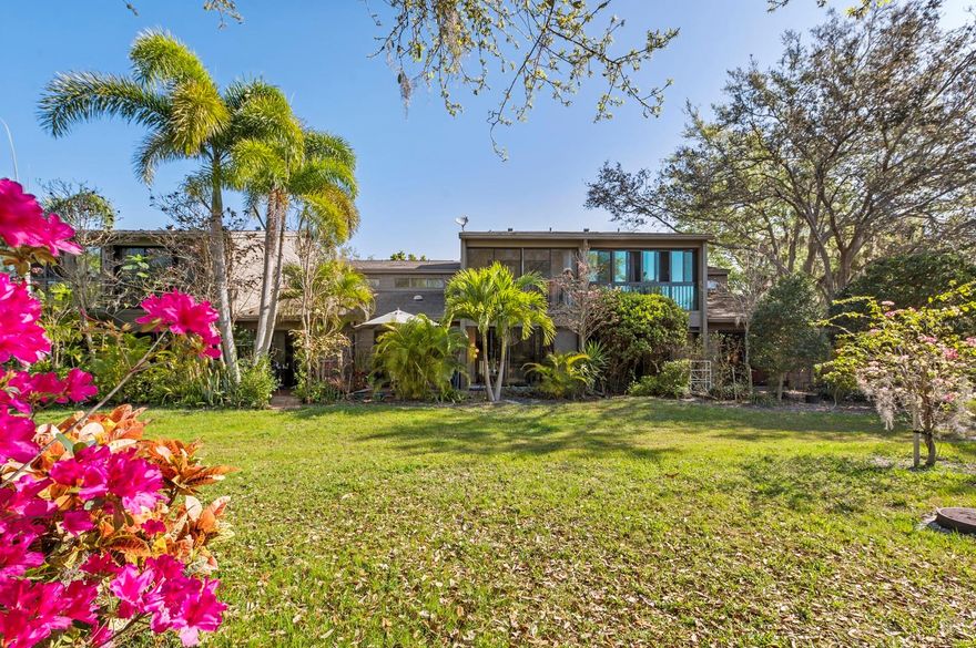 This 3-bedroom, 3-bath duplex townhouse is the epitome of gracious living. Its blend of open concept and generously sized rooms, soaring cathedral ceilings, abundant light and storage, front and back patios and a screened-in sitting area off the primary upstairs bedroom make this a stylish and welcoming home. In addition, there’s a downstairs family room/den, a separate laundry utility room, and a secure external storage shed and covered carport.  Upon entering, you will immediately be enchanted by the luxury vinyl flooring that looks exactly like whitewashed oak, and the sun beaming through the back window wall will further draw you in. A white oak and stainless steel stairway extending up from the main living area provides access to the comfortable layout of the second floor. A thoughtful renovation in 2023 resulted in a completely remodeled kitchen and bathrooms, a 14-foot custom walk-in closet off the master as well as a built-in vanity and large medicine cabinet with lights. The streamlined cabinetry throughout adds an elegant touch. Brand new high capacity AC system, hot water heater and electrical panel complete the renovation.  This lovely residence is well-situated within the lush beauty of this popular condo enclave—just steps from its back patio is the Pavilion clubhouse and pool. Also, you are free to enhance your breakfast with the bounty of the fruit orchard a short walk away. To sum up, If you are looking for wonderful home where you can entertain, host family and friends, and enjoy the warm community of Pelican Cove with its myriad of activities and cultural events, your search ends here.