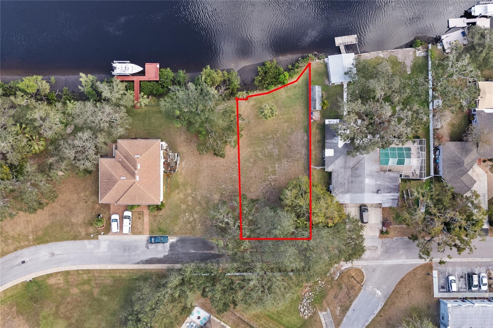 HIGH AND DRY on the PITHLACHASCOTEE (COTEE) River with easy deep-water access to the Gulf of Mexico. The waterfront lot elevation offers a rare opportunity to build on-grade, no stilt house. This will save tens of thousands in construction costs. A private gated community offers a peaceful, quiet and secure riverfront setting. Just add your own dock and lift. Deep water for large boats. Lot is cleared and ready for building. Located near downtown New Port Richey, just south of Main Street. New Port Richey is a golf cart friendly community offering numerous restaurants, breweries, Live theater, shopping, and entertainment. Music and festivals are held regularly at Sims Park. Local activities include Farmers Markets, craft shows and much more. Great kayaking up stream to Nature’s Own Parks. A short trip downstream towards the Gulf of Mexico takes you to several waterfront restaurants on the river. Whiskey River, Catches, Whiskey Joes, Hooters, to mention a few.. Bring your boat and build your waterfront dream house today. Tampa International Airport is a short 45 minutes away. Lot next door available for sale as well. MLS #W7870859