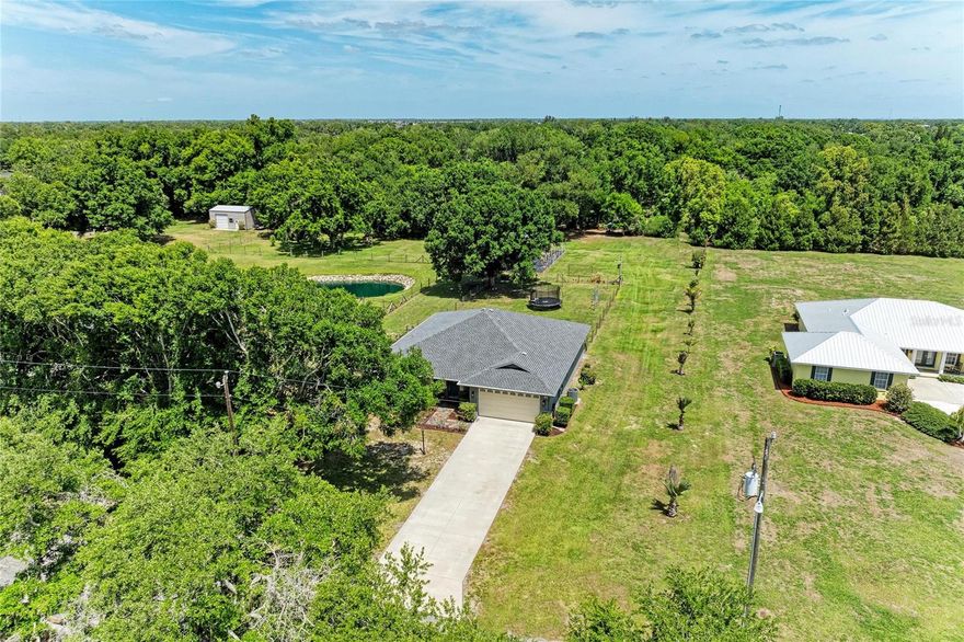 Welcome to your own private slice of paradise with NO HOA and NO CDD! Bring all the toys including the RV as the 220/110 volt hook up is already waiting for you! This impeccably maintained 3-bedroom, 2-bathroom single-family home sits on a cross-fenced 1-acre property, offering the perfect blend of peaceful country living with everyday convenience. The updates in the home and property are numerous, be sure to ask for a complete list of the upgrades and features!
From the moment you arrive, you’ll appreciate the pride of ownership throughout, starting with the exterior curb appeal, beautiful landscaping, and cozy covered front porch with bench seating. Inside, the home features vaulted ceilings, fresh interior paint, new carpet in one of the bedrooms and thoughtful updates that create a bright, open, and inviting atmosphere. A newer roof adds peace of mind, while the well-maintained condition makes this home truly move-in ready. All bedroom closets have custom built-in storage systems, and there is a reverse osmosis system in the kitchen too! Step out through your French doors to your freshly painted screened in and covered back porch, while admiring your multiple vegetable gardens. Feel secure knowing you have an exterior generator hookup, emergency water tanks (approx. 1,200 gallons) and a wired home security system with 8 channels.
On your 1 acre sprawling property you’ll feel truly free. Harvest your fruits and vegetables in the existing multiple gardens, and enjoy the large chicken pen with hatching area and a large rabbit pen. The chickens and rabbits can be purchased too! 19 Rhode Island Red-hatched egg layers and “Florida White” rabbits, 1 buck & 2 doe. The property includes a plethora of plants including Travelers Palm, Silver Bismark Palm, Triangle Palm, East African Acacia, Norfolk Pine, Bougainvillea, Bromeliad, Mango, Guava, Fig, Ponderosa lemon, Persian lime, 2 types of banana trees, calamondin-citrus, castor bean, coconut, ginger, desert rose, hibiscus, aloe vera, staghorn fern, multiple succulents, pineapple, queen of the night and more! This property is perfect for those looking to embrace a more self-sufficient lifestyle.
Enjoy the private, tucked-away feel, yet still just minutes from everything you need—grocery stores, shopping, and a variety of restaurants—making this an ideal location that offers both convenience and tranquility. If you’ve been searching for space, privacy, and flexibility without sacrificing location, this is the one.