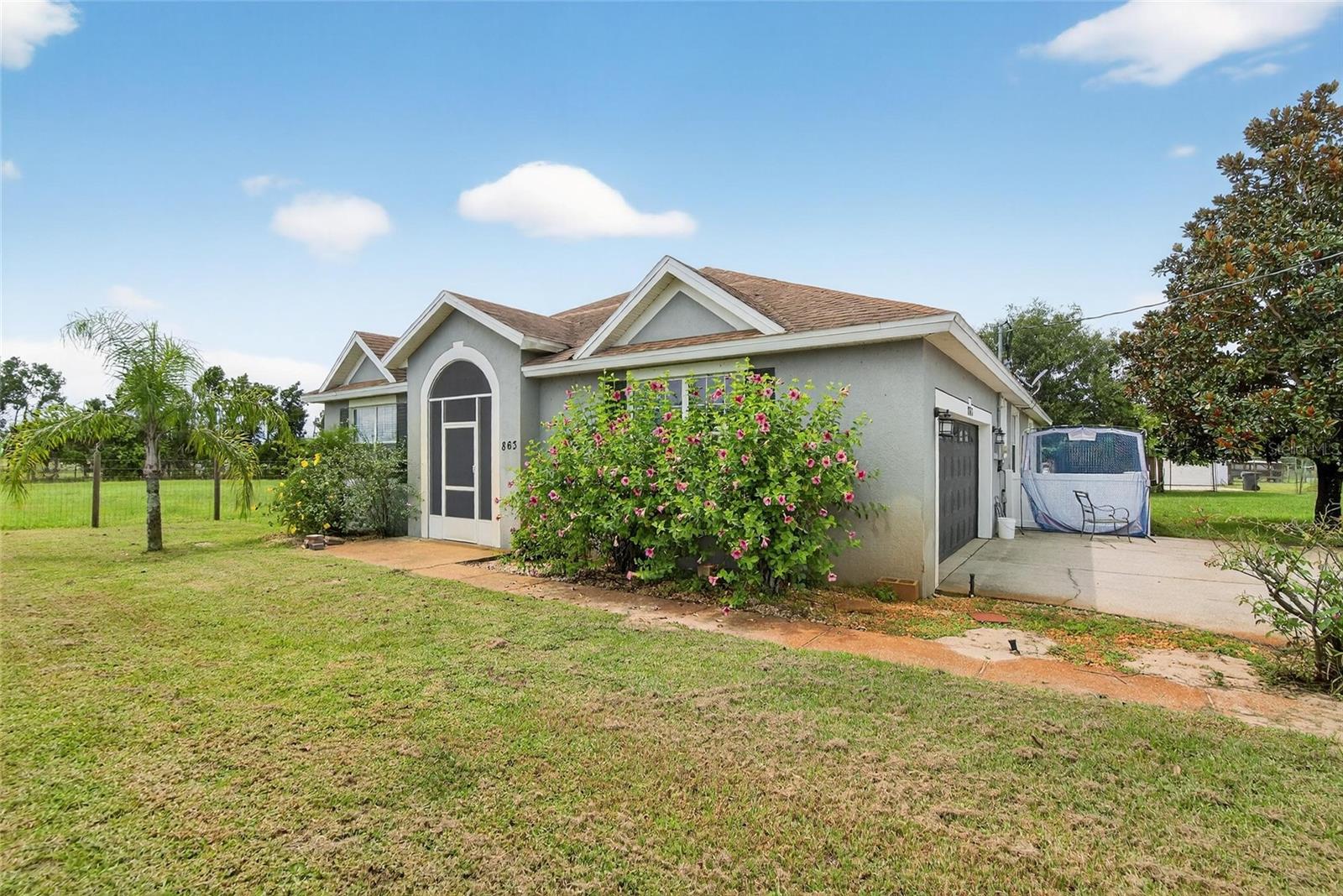 RARE FIND – TWO SINGLE-FAMILY HOMES ON OVER AN ACRE! This unique property in Lake Wales offers the perfect setup for a large multi-generational family, in-law suite, or an excellent income-producing rental opportunity. The fully fenced lot is dotted with fruit trees and provides privacy and space to enjoy. (Home in front (4/2) is now going completely repainted and carpets cleaned)
The main home features 4 bedrooms, 2 bathrooms, and 2,170 sq. ft. of updated living space, including fresh interior paint, new flooring in the main living areas, a spacious eat-in kitchen, and a large great room with combined dining and living areas. Step out to the screened back patio and take in the peaceful yard.
The guest home, built in 2016, offers 3 bedrooms, 2 bathrooms, and 1,300 sq. ft. of heated living space. Highlights include an updated kitchen and baths, a large open kitchen-to-living layout, inside utility, 2-car garage, and screened patio. This second home also has its own private driveway and fencing, making it ideal as a rental or in-law residence.
Don’t miss this rare opportunity—two move-in ready homes on one beautiful property with endless possibilities!