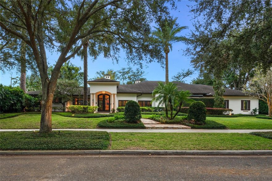 Straddling the charming and highly desirable Winter Park/Orlando border, this exceptional, newly painted 4-bedroom, 4.5-bath custom home offers an extraordinary living experience. Built with the utmost attention to detail and remodeled by the celebrated Slocum Platts in 2007, this residence sits on an expansive triple lot with 150 feet of frontage and nearly half an acre of lush, professionally designed landscaping by Joe Brooks, and elegant lighting by McLeod Landscaping. It is a home that perfectly blends old-world craftsmanship with modern luxury and convenience. Adorned with national accolades for its intentional design and ground-breaking smart home features by Zio, the house has been transformed into an intuitive smart environment without any infringement on the tranquility of its tropical oasis. The backyard is a true testament to thoughtful landscaping design, anchored by the stunning Yellow Tabebuia tree. This remarkable tree stands proudly as the centerpiece of the lush garden, offering both beauty and a touch of interesting history. The garden’s privacy and tranquility are enhanced by the gentle sound of water flowing from the fountains and the serene ambiance of the surroundings. Step inside through the exquisite custom-made double iron front doors, hand-forged in Mexico, and you’re immediately enveloped in the warmth of the home’s sophisticated design. Throughout, you’ll find custom finishes that speak to timeless elegance, like the stunning antique wood-carved double doors in the main bedroom and the beautifully weathered Pecky Cypress ceiling that adds character and richness to your favorite spot. The heart of this home is its expansive living areas, bathed in natural light from high-end Marvin doors and windows that offer sweeping views of the private backyard and its serene surroundings. The living room, anchored by one of three fireplaces, serves as a perfect gathering place, with its stately and cozy ambiance enhanced by the soft glow of natural light filtering through the trees. Adjacent, the den, where you can unwind or enjoy the theater system, creates an immersive cinematic experience. The coveted kitchen, with its top-of-the-line appliances and custom cabinetry, invites effortless entertaining. It flows seamlessly into the dining area, and from there, to the covered patio — an extension of the home’s living space. Here, the beauty of the outdoors is on full display. Go ahead, immerse yourself. This home’s outdoor oasis is truly something to behold, where every step feels like a quiet escape into nature’s embrace. The saltwater pool, heated for year-round enjoyment, is self-draining and self-filling, ensuring consistent water levels without the need for constant maintenance. A flagstone patio hardscape will lead you down the entire length of the oasis. For those who prefer a more intimate outdoor retreat, two outdoor showers offer a unique way to refresh amidst the beauty of the landscape. Get lost in the vast and private enclosure that the bamboo and dense greenery bestow. This backyard is a lush, tropical oasis that transports you to a private paradise, where vibrant greenery and exotic plants flourish in every corner. Comfortable accommodations are not forgotten here. The air-conditioned pool bath and garage add another layer of convenience, and the whole-house speakers allow you to enjoy your favorite music while soaking in the beauty of your surroundings from any location.
