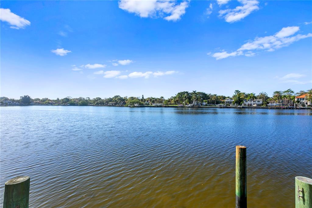 Waterfront home on Snell Isle! This charming ranch-style home sits on the shores of the protected waters of Coffee Pot Bayou, offering stunning views of the tranquil bayou, and is just minutes from bustling downtown St. Petersburg. The covered front porch makes an inviting entry for this 2-bedroom, 2.5-bath, 2,780-square-foot heated home nestled on the generous-sized lot boasting 109 feet of waterfront. Hardwood floors, custom wood built-ins and a wood-burning fireplace grace the stylish living room. The kitchen features hardwood floors, stone countertops, stainless appliances, a wine refrigerator and picture-perfect water views from the kitchen window. Adjacent to the kitchen is a large laundry and craft room, and originally a two-car garage. Timeless Mexican saltillo tile covers the floors of the dining room, sunroom and guest bedroom. The sunroom overlooks the beautifully landscaped backyard with brick patios and pathways and incredible views of Coffee Pot Bayou, teeming with birds and wildlife, bringing endless enjoyment to anyone lucky enough to spend time in the home. The newer dock has water and electric power and there is an oversized detached two-car garage with a workshop and extra storage room. This is a fabulous opportunity to renovate or build new in the highly desirable Snell Isle neighborhood!