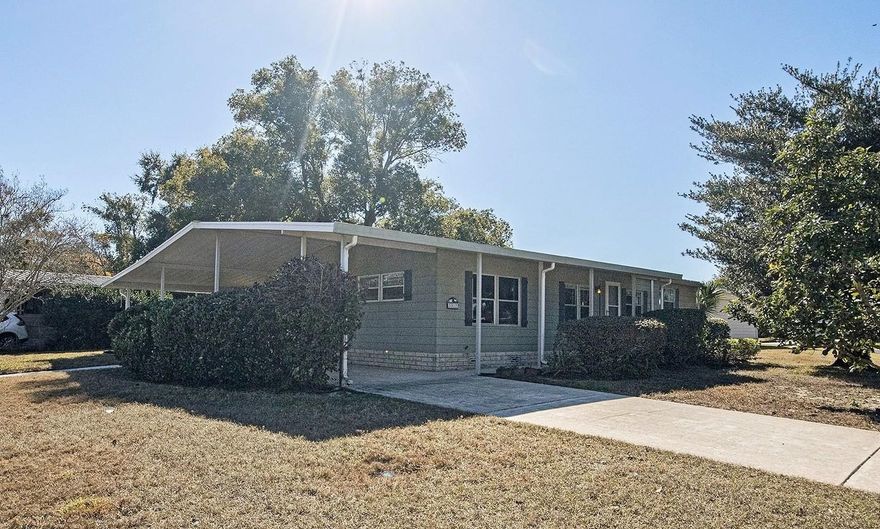 One or more photo(s) has been virtually staged. IMPROVED PRICE MAKES THIS HOME EVEN MORE AFFORDABLE.  Located in Zellwood Station, close to Orlando and The Villages? This well-maintained 2-bedroom, 2-bath home sits on a large corner lot in the desirable golfing community of Zellwood Station, an active 55+ community spanning over 800 acres of beautifully maintained grounds.  The home features a split floor plan, indoor laundry with storage, and a two-car carport. Enjoy Florida living year-round in the enclosed Florida room and covered side patio, perfect for relaxing or entertaining. The spacious outdoor area offers plenty of room for gardening, gatherings, or simply unwinding under the shade tree.  Zellwood Station offers an impressive list of amenities, including: Internet, Wi-Fi, and two TV hookups, Lawn care (mowing, edging, and driveway blowing), Trash and yard waste pickup, 24-hour security with manned gatehouse, On-site restaurant, Four swimming pools, Championship 72-hole golf course, Tennis courts, pickleball, fitness center, and clubhouse, A full calendar of social activities and events, Fishing from stocked ponds and so much more.  Conveniently located near shopping at Mt. Dora, dining, medical facilities, Orlando attractions, and The Villages, this home offers comfort, community, and value — all in one place.  Note: some amenities may not be included in the HOA fee.