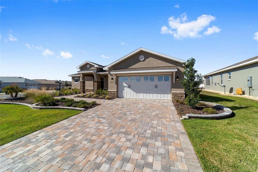 Perfectly positioned on a spacious corner lot, this beautifully upgraded 2-bedroom, 2-bath Livingston model with a flex space offers standout curb appeal with stone accents,  a paver driveway, and raised landscaping. Inside, luxury vinyl plank flooring flows throughout an open, light-filled layout highlighted by tray ceilings with crown molding in the great room and primary suite. The kitchen shines with granite countertops, stainless steel Whirlpool gas appliances, tile backsplash, staggered cabinetry, pantry, and a stone-wrapped island accented by pendant lighting; ideal for entertaining. The front flex room, enhanced with a partial wall, provides the perfect space for a home office, dining area, or additional living space. Retreat to the primary suite featuring a walk-in closet and spa-inspired ensuite with dual quartz vanities and a zero-entry tiled shower with built-in bench. Enjoy Florida living on the screened lanai complete with, TV mount, and pull-down shade, plus an extended two-car garage, laundry room with cabinets and sink, and water softener. Additionally, the home has white blinds, Lutron smarthub, Lutron dimmable switches, and amazon smart device. This home delivers style, comfort, and thoughtful upgrades throughout. Located in Ocala's premier, gated, active 55+ community, loaded with amenities, including golf cart access to 2 shopping centers.