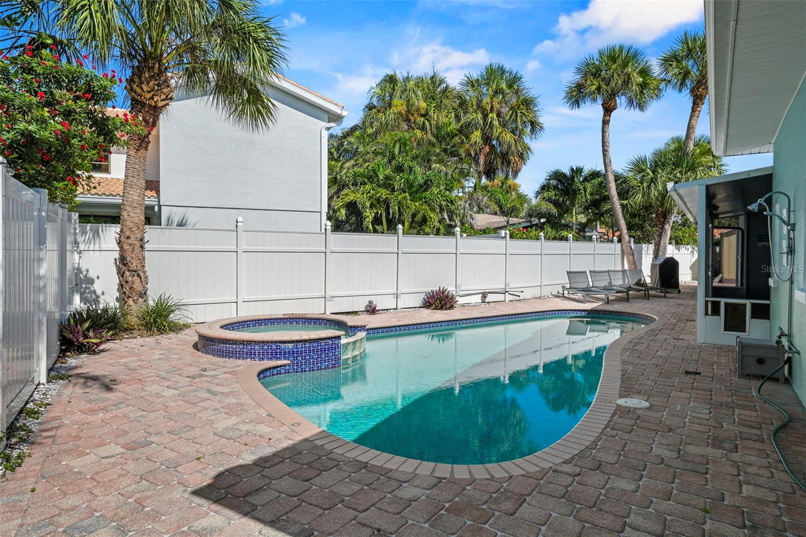 Coastal elegance meets timeless charm in this beautifully updated residence located in the exclusive neighborhood of Carlouel on North Clearwater Beach. This 4-bedroom, 3-bathroom home offers the perfect blend of luxury and livability, nestled on a sprawling 117 x 79.5 fully fenced lot with lush tropical landscaping and gated access on both sides. Step inside to discover a brand-new kitchen with stunning granite countertops, stainless steel appliances, and an oversized island—ideal for entertaining. Gorgeous oak floors, plantation shutters, and thoughtful design details flow throughout the home. The open living spaces extend effortlessly, to a screened-in lanai with a doggie door, overlooking a sparkling pool, hot tub, and an outdoor shower—your own private oasis. Enjoy the convenience of a circular driveway, a carport on one side, and additional parking with a shed on the other. Located just steps from the private beach access reserved for Carlouel residents, this home is perfectly situated in a golf-cart friendly community with unmatched privacy and prestige. A rare opportunity to own a slice of paradise in one of Clearwater Beach's most coveted enclaves.