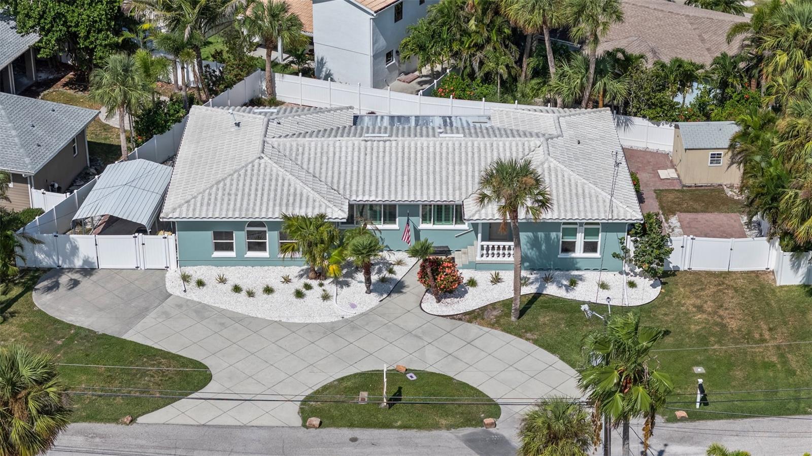 Coastal elegance meets timeless charm in this beautifully updated residence located in the exclusive neighborhood of Carlouel on North Clearwater Beach. This 4-bedroom, 3-bathroom home offers the perfect blend of luxury and livability, nestled on a sprawling 117 x 79.5 fully fenced lot with lush tropical landscaping and gated access on both sides. Step inside to discover a brand-new kitchen with stunning granite countertops, stainless steel appliances, and an oversized island—ideal for entertaining. Gorgeous oak floors, plantation shutters, and thoughtful design details flow throughout the home. The open living spaces extend effortlessly, to a screened-in lanai with a doggie door, overlooking a sparkling pool, hot tub, and an outdoor shower—your own private oasis. Enjoy the convenience of a circular driveway, a carport on one side, and additional parking with a shed on the other. Located just steps from the private beach access reserved for Carlouel residents, this home is perfectly situated in a golf-cart friendly community with unmatched privacy and prestige. A rare opportunity to own a slice of paradise in one of Clearwater Beach's most coveted enclaves.