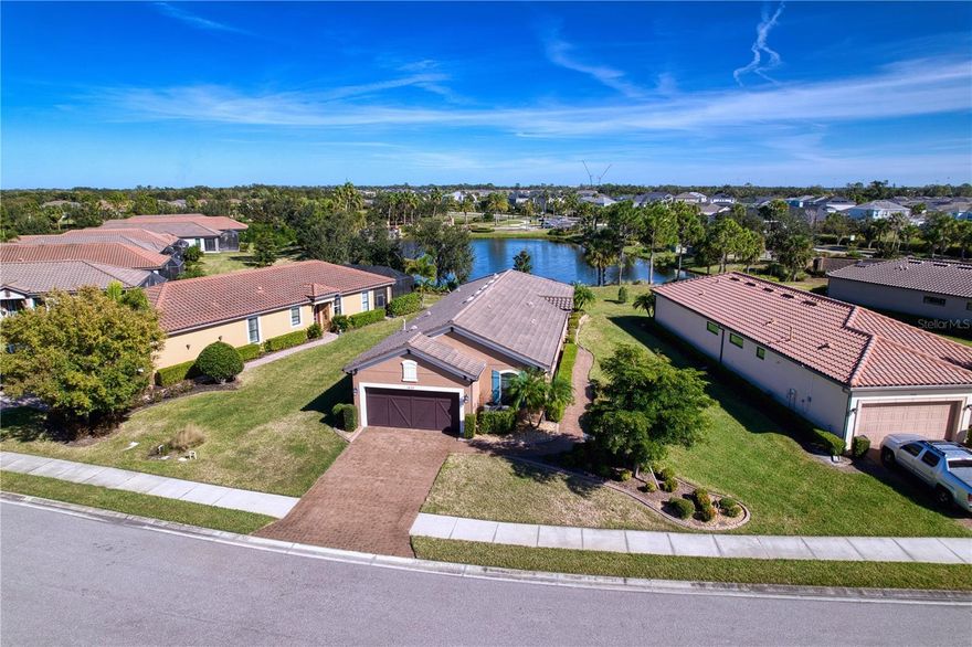 Stunning 1,920 Sq. Ft. Home in Esplanade at Artisan Lakes, Palmetto, Florida! Welcome home to this beautifully maintained one-owner residence in the ever-popular Esplanade at Artisan Lakes. From the moment you step through the front door, your eyes are drawn straight through the sliding lanai doors to a breathtaking water view complete with a cascading waterfall creating a tranquil scene you’ll love both day and night. This maintenance-free home offers a spacious, open-concept layout featuring a family room, dining area, open kitchen, flex room/office, and a split-bedroom plan with a primary suite plus two additional bedrooms. Gorgeous hard-surface flooring, for easy living and a clean, modern look in main living areas and primary bedroom. Recent updates and features include: • Brand-new hurricane impact windows and accordion-style shutters across the back for peace of mind • New HVAC system (June 2024) and top of the line! • Updated master shower, and updated appliances (washer, dishwasher, and microwave all replaced within the last 2–4 years) • Fresh landscaping with decorative curbing, crown molding in main living areas and primary suite • New smoke alarms (replaced approximately 8 months ago) • Gutters installed, rounded wall corners, and elegant Cypress wood tongue-and-groove ceiling in the lanai • In-wall pest control system and a customizable seasonal doorbell feature. Enjoy the serene lake view with its waterfall feature...what a perfect backdrop for morning coffee or evening relaxation! Located in a vibrant, growing area with new restaurants, shopping, and medical facilities nearby.  Esplanade at Artisan Lakes offers resort-style amenities including: Two luxurious pools, State-of-the-art fitness center, Tennis & Pickleball courts plus A full calendar of social events. This home combines comfort, security, and elegance & is truly move-in ready and sure to impress its next owner!l