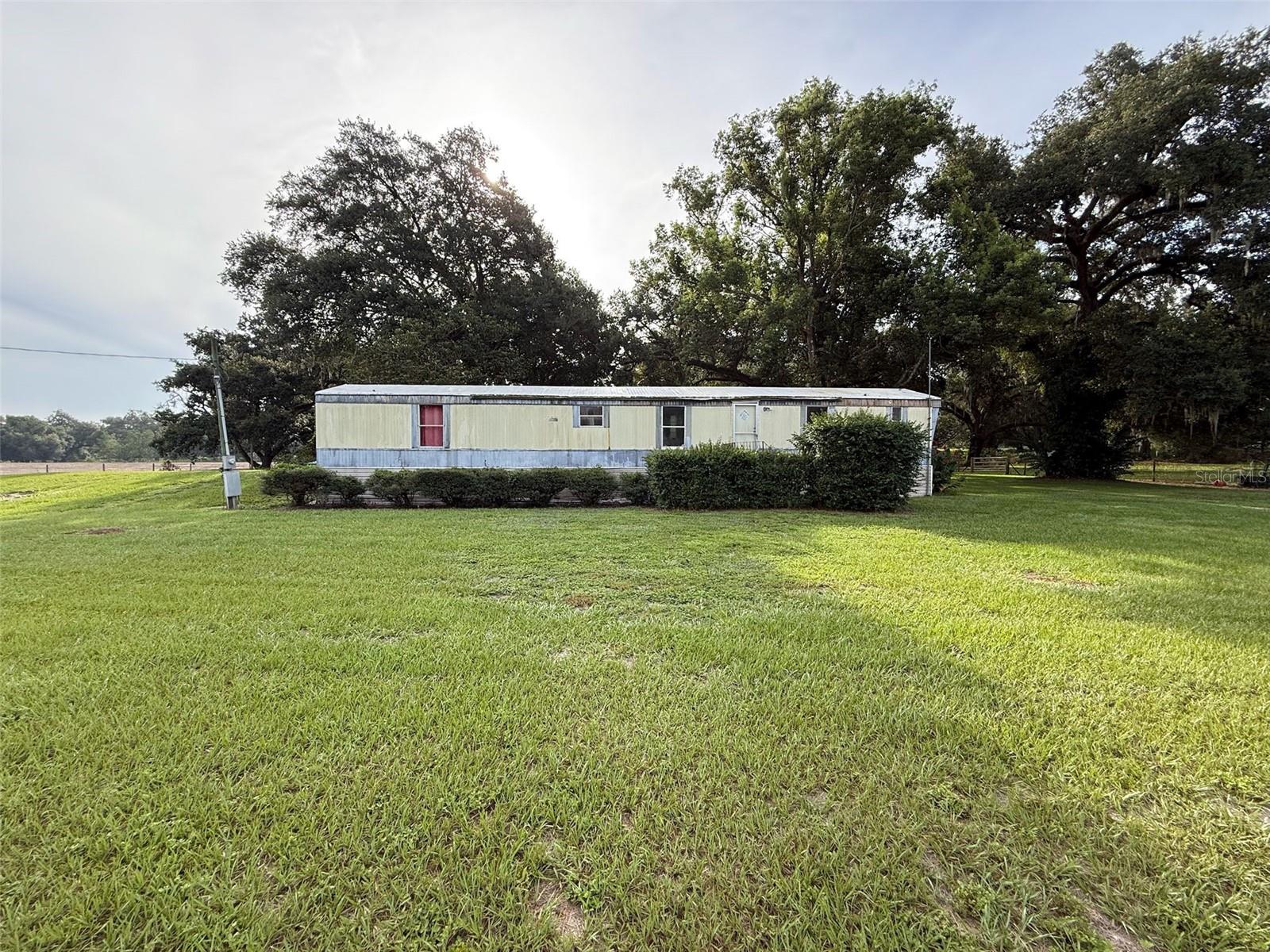 *** Opportunity Knocks in Trilacoochee!*** Welcome to 21146 US Highway 301—a spacious 4-bedroom, 2-bath single Wide mobile home situated on a beautiful 2.5-acre parcel completely fence in the peaceful community of Trilacoochee. While the home needs updating and TLC, the land is full of potential offering 2 wells( 4" submersible, 3" above ground)Septic,2-200 amp Electric.With high-visibility frontage on Highway 301, this property is an ideal candidate for future commercial zoning—a smart investment in a growing area. Whether you're looking to create a mini-farm, homestead, or invest in land for the future, this is your opportunity.A small pond adds charm, and the land is perfect for raising chickens, goats, horses, or growing your own vegetables. You could even remove the existing mobile home and build a new custom home—which may help you save significantly on impact fees (buyer to verify with county).There's also potential to divide the property into two one-acre lots.?? Versatile use—residential, agricultural, or commercial potential?? Offered As-Is – Bring your vision and make it your own!
