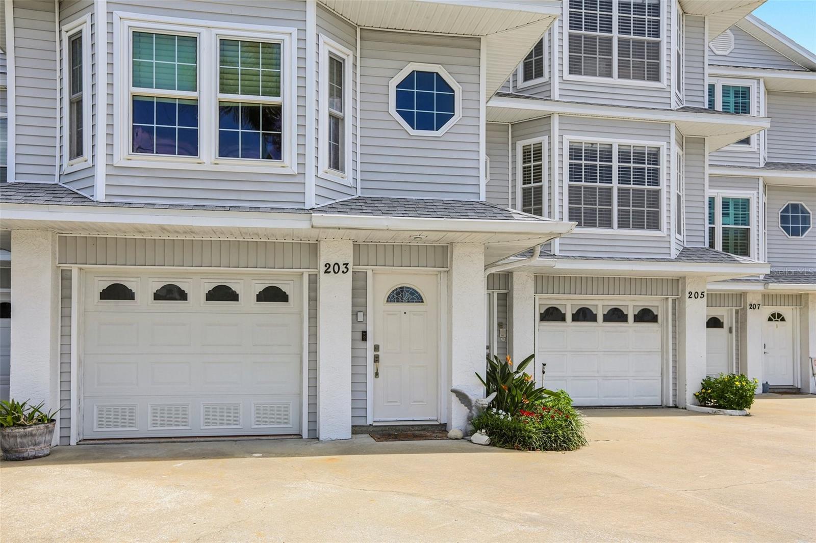 Tucked into the sought-after Dolphin Cove neighborhood just a block from St. Pete Beach, this spacious 3BR/3BA townhouse offers over 2,400 sqft of thoughtfully updated living space. With only 7 units in this complex, low association fees, and quiet neighborhood, this home is truly a dream! Recent improvements include a new roof (2025), new Boesch dishwasher (2025), fresh carpet in all bedrooms and stairs (2024 and 2025), new electrical junction box, up to code doors on first level, a new garage door (2024), and new Hardy board siding in the garage and first level storage. Also featuring a first floor water protected garage and storage -hardy board and tile walls and floor. The exterior has been upgraded with a brand-new deck (2025) leads to the pool area—complete with a doggy door for four-legged companions. Inside, enjoy a bright open layout with coffered ceilings, a fireplace, and a chef’s kitchen. A bonus room opens to a private patio surrounded by tropical landscaping. Upstairs, the primary suite features a private balcony, beautiful water views, and a custom walk-in closet. Additional features include impact resistant doors and windows. Located near World Famous Vinoy, Starbucks, restaurants, Publix, Walgreens, and the beach. Come experience the charm, comfort, and character of this beachside retreat—you may not want to leave!