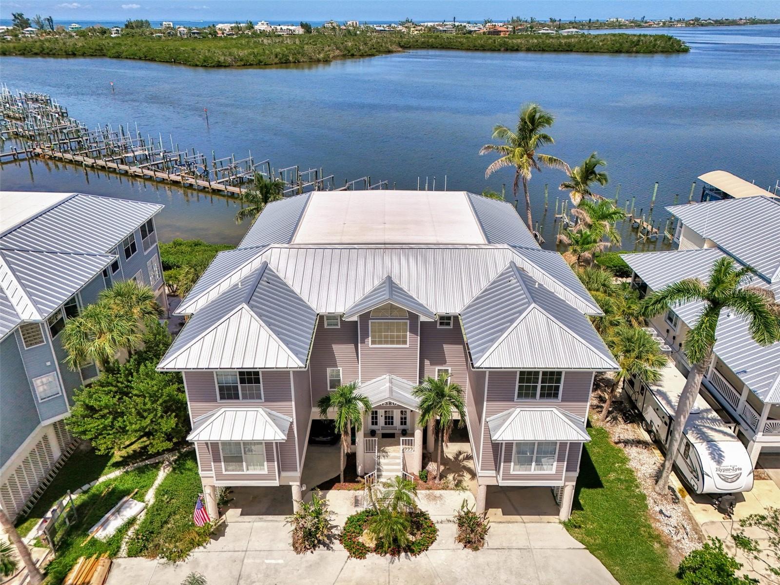 Don’t miss this exciting opportunity to own this top floor end unit condo in the highly sought after community of Mariner Village located on the water’s edge of beautiful Sandpiper Key. This 12-unit community offers waterfront living right on Lemon Bay and delivers unobstructed sunset views that will bring you hours of peace and enjoyment. Right from the tiled oversized screen lanai you will have a front row seat to some of Florida’s most exciting wildlife, including dolphins, manatees, and tropical birds. There are 3 buildings in the community, and each building has its own private pool to be shared amongst its 4 units. The exterior has a brand-new roof and new siding. The pool area is scheduled to be refinished, and all new landscaping will be installed. Each unit enjoys an oversized one car garage found underneath the building with an additional covered carport area. Living on the top floor is not a problem with the convenience of the elevator that takes you from the ground level, all the way up to your front door. When you enter the condo, you will find that all of the drywall on the walls and ceilings has been replaced and refinished, and there is new luxury vinyl plank flooring in a neutral beach tone that runs throughout all of the rooms in the unit, with tile in the bathrooms, making this condo completely carpet free! All outlets and light fixtures were updated with new electric, fresh paint is found throughout, and new fans and light fixtures were also installed. The large living room captures sweeping water views from every angle and the oversized lanai has an additional storage room. There is both an eating space in the kitchen, as well as a dining area in the main living space. The kitchen is massive in size and offers ample cabinet and counter space. Down the hall you will find a light filled primary suite with 2 walk-in closets, and a large primary en-suite with deep soaker tub and a walk-in shower. This end unit being in the first building, allows you to enjoy arguably some of the most beautiful views the association has to offer, looking both North and South onto Lemon Bay from the primary bedroom and bath. There is a nice sized second bedroom with a large closet upfront that also enjoys water views, and a second bathroom just off that bedroom for convenience. In the hall you will find an in-unit laundry area. Mariner Village is ideal for someone seeking a permanent home, a part-time seasonal residence, or as an investment with great rental potential. Less than a mile from Englewood Beach, this location is prime with easy access to local watersports, restaurants, bars, and tons of activities. Historic Dearborn St with its charming restaurants and shops is just a short drive or bike ride away. Whether you are seeking a peaceful Florida retreat or an income producing vacation home, this condo is the perfect opportunity to enjoy affordable waterfront living. The owner is offering to sell their boat dock slip with the unit at Sandpiper Key Yacht Club, located on the dock with the deepest water access just behind the condo!