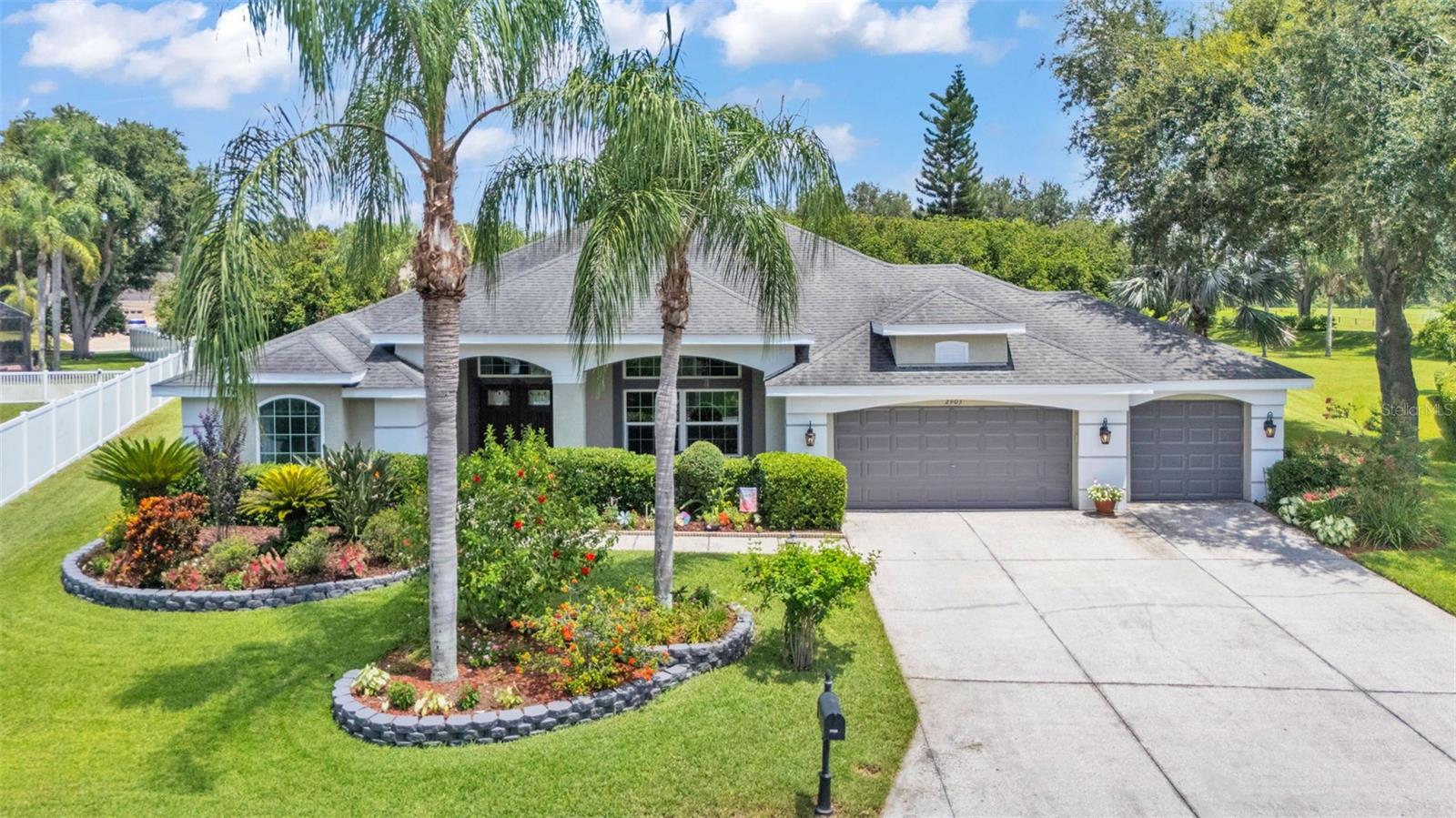 Welcome to your own private retreat! This spacious 4-bedroom, 3-bathroom pool home offers the perfect blend of comfort, functionality, and style. Approaching the home, you’re greeted by the stunning professionally landscaped grounds featuring stone-lined flowerbeds with palm trees, spotted with brightly colored flowers and bushes. A covered front porch leads to a double-door entry. Step inside to find an open and inviting floor plan with abundant natural light that highlights the gorgeous travertine tile floors. The layout of the home is ideal for both everyday living and entertaining with combined entertaining spaces. The heart of the home is the generously sized kitchen, complete with quartz counters, an island with additional storage, plenty of cabinetry, a closet pantry, a butler’s pantry, a wine/drink fridge, and a large breakfast bar that opens to the family room. The family room has hand-scraped Brazilian hardwood flooring, vaulted ceilings, and two sets of sliding glass doors that lead out to the lanai and pool. There’s a separate formal living room and a formal dining area with wainscoting and crown molding for dinner parties or gatherings. The split-bedroom layout ensures privacy, with a luxurious primary suite featuring bamboo floors, dual walk-in closets, a sitting room that leads to the lanai, and an en suite bath with quartz counters, a soaker tub, and a walk-in glass-enclosed shower. Step outside to your personal oasis: a screened-in lanai overlooking the sparkling in-ground pool, surrounded by tropical landscaping and plenty of patio space for lounging or outdoor dining. Whether you’re hosting pool parties or enjoying a peaceful morning coffee, this backyard is a dream come true. Additional highlights include a separate dedicated home office, a three-car garage, a water softener system, double-pane windows in the front and back of the home, and a prime location close to schools, shopping, and dining. Don’t miss your chance to own this beautiful home—schedule your private tour today!