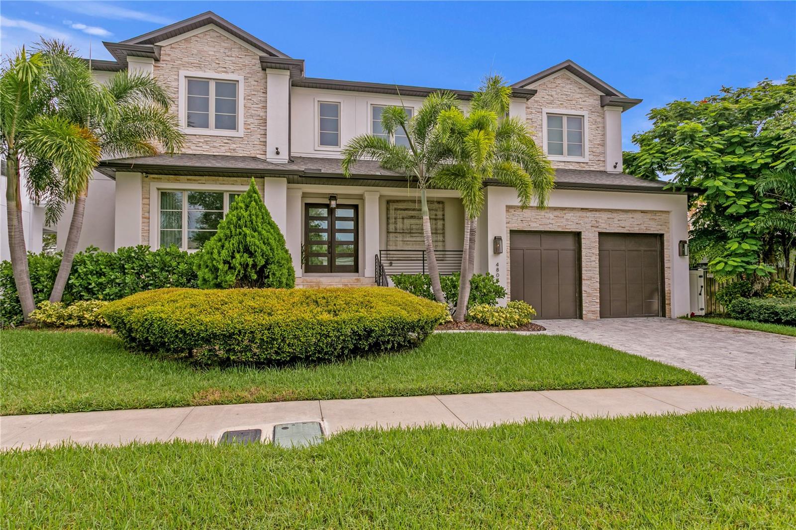 Welcome to 4807 W Longfellow Avenue, an exceptional luxury residence nestled in the Sunset Park neighborhood of South Tampa. Completed in 2017, this elegant 4-bedroom, 4-bathroom plus Bonus Room (possible 5th bedroom), smart home offers over 5,100 square feet of refined living space. From its stately two-story foyer to its thoughtfully designed interior spaces, every detail of this home speaks to quality and craftsmanship. The heart of the home is a chef’s dream kitchen, featuring top-of-the-line Thermador stainless steel appliances, including a 48-inch built-in refrigerator, professional gas range with double ovens, sleek Quartz countertops, a large center island, breakfast bar, and an oversized hidden walk-in pantry. The open-concept design flows seamlessly into a spacious great room with gas fireplace, perfect for entertaining or relaxing with family. A formal dining room, mudroom, full bath, and a versatile fifth bedroom/media room complete the well-appointed first floor. Upstairs, the luxury primary suite spans the east wing, offering two boutique-style walk-in closets, a morning kitchen with a sink plus beverage fridge, and a spa-inspired bathroom adorned with Carrara marble dual vanities, an oversized rainfall shower, and freestanding soaking tub. Step outside through elegant French doors to discover your own outdoor oasis. The screened lanai features a complete outdoor kitchen with a gas grill, professional hood, beverage refrigerator and undermount stainless sink; an ideal setting for alfresco dining and entertaining year-round. Additional upgrades include oil-finished Maxi Line engineered hardwood floors throughout, JELD-WEN impact-resistant Low-E insulated windows, smart home technology, and an oversized two-car garage with 15-foot ceilings. Located within a top-rated school district and just minutes from Tampa International Airport, downtown Tampa, major bridges, fine dining, and premier shopping, this home offers the perfect balance of elegance, convenience, and modern living.