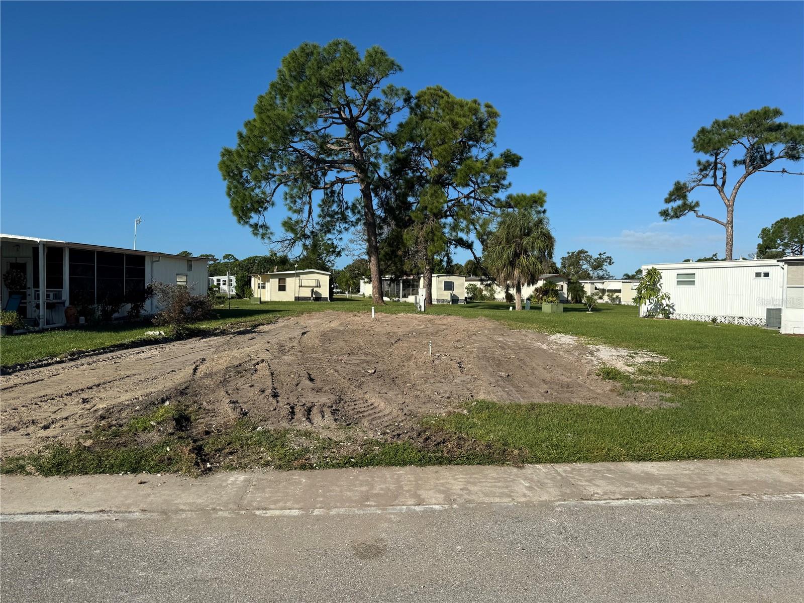 Beautiful cleared lot with utilities ready to make your own. It has a clubhouse with a heated, ?olympic-size pool and many other amenities. Shuffleboard Courts, Horseshoe Pits, Pickleball Courts, Tennis Courts, Bocce Courts, Ping Pong Tables,Heated Pools, Laundry Facility, Billiard Room, Fitness Center, Card Rooms, Library, Ceramic Building with Kiln, Dart Room. Also to many activities to list.