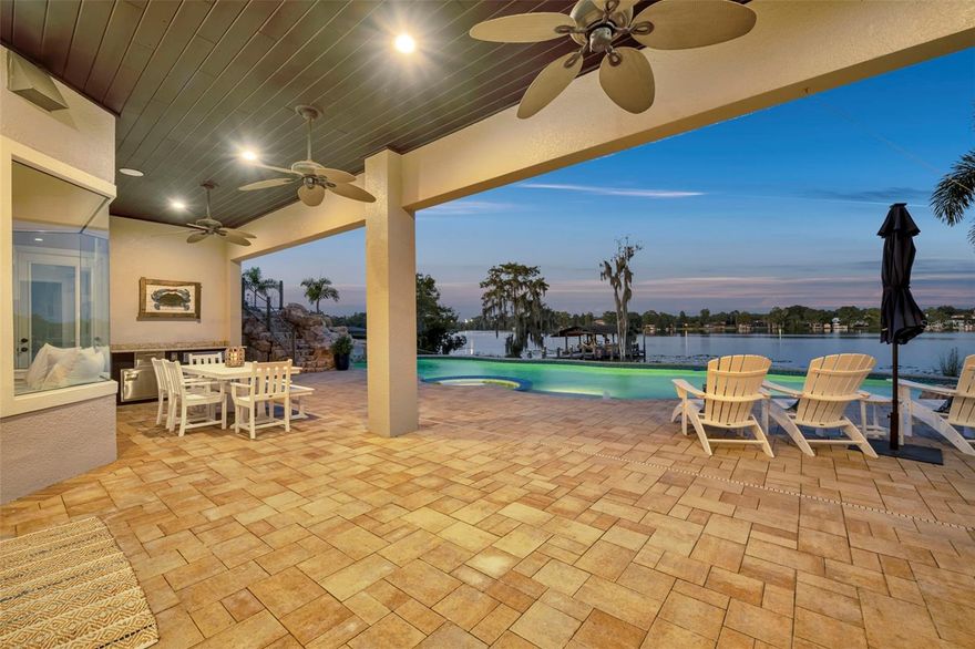 Under contract-accepting backup offers. Luxury, adventure, and memories in the making!  Breathtaking Lakefront Luxury in Kingsbridge West!!  From the moment you step inside, the view of Long Lake takes center stage—wide open water, endless skies, and a lifestyle that feels like vacation every day. This custom 5-bedroom estate with immense bonus room blends elegance with fun, creating the ultimate retreat in the heart of Oviedo.  The brand-new chef’s kitchen with Wolf appliances, quartz counters, and custom cabinetry is designed for both entertaining and everyday living. A built-in lakeview bench invites you to linger, while the open-concept family room with fireplace and sliding glass doors keeps the water in constant view.  Step into the owner’s retreat, where bay windows frame the lake, a private lanai entrance opens to morning breezes, and the spa-inspired bath features dual vanities, walk-in shower, and jetted soaking tub. Upstairs, the bonus/game room is a dream space for entertaining—oversized, light-filled, and big enough for pool, darts, and theater seating. This level also includes a private bedroom with its own exterior entrance, perfect for multi-generational living, guests, or an au pair.  The outdoors rival any resort: amazing custom pool with spa, grotto style waterfall, and rock slide, an expansive lanai with summer kitchen, grill and multiple covered lounge areas. Even better, your private dock and boathouse with slip, hoist, and utilities make it easy to live the ski-lake lifestyle.  A versatile three-car garage with pass-through bay provides the ultimate flexibility—ideal for storing an RV, boat, or even creating your own lake-view home gym.  Tucked inside the sought-after Kingsbridge West community, this estate offers the perfect blend of serenity, prestige, and convenience—just minutes to Oviedo’s top-rated schools, shopping, dining, and easy access to Orlando.  Welcome Home!!