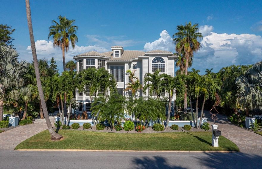 Experience island living at its finest in this exquisite coastal retreat in the historic Village on Longboat Key. This home offers a refined blend of relaxed coastal charm and timeless sophistication throughout more than 3,300 heated square feet. The meticulously designed interior includes elegant crown molding, coffered ceilings, custom doors, impact windows and an elevator from the garage to each level. The great room features dramatic ceiling height and opens to a large covered terrace overlooking an exceptionally private backyard, creating an ideal setting for quiet evenings and effortless entertaining. The gourmet kitchen is a chef’s dream with rich wood cabinetry, granite countertops, natural gas cooktop, a pot filler, center island with sink and second cooktop, and a bright breakfast nook that opens to a covered terrace, ideal for morning coffee. Adjacent dining and living areas flow seamlessly and are enhanced by a coffered ceiling and French doors to the charming terrace. The second-level primary suite serves as a serene retreat with polished wood floors, an intricate coffered ceiling, a comfortable seating area, and a private covered balcony for enjoying peaceful moments under the morning or evening sky. Elevated views and sound of ospreys add to the sense of tranquility. The suite also features a spacious en-suite bath with soaking tub and two walk-in closets. Three additional bedrooms provide comfort and flexibility for guests or work needs. Outdoors, a resort-style saltwater pool and spa with integrated features are surrounded by lush landscaping and generous lounging space. The expansive ground-floor lanai and outdoor kitchen further enrich the indoor-outdoor living experience. A circular brick drive accommodates more than 10 vehicles, and the oversized two-and-a-half-car garage and first-level area offer abundant storage, ideal for bicycles, golf carts, kayaks and more. The home and pool are centered on a 12,000-square-foot lot, and an adjacent 6,000-square-foot parcel is also available from the same owner for those interested in expanding or creating a larger compound. This unique golf cart friendly community is surrounded by waterfront restaurants, quaint shops, cafés, fitness centers, fishing piers, a boat ramp on Sarasota Bay, kayak launch areas and a pristine Gulf beach just moments away with no mandatory HOA. We invite you to experience this remarkable home in person to fully appreciate its beauty and lifestyle.