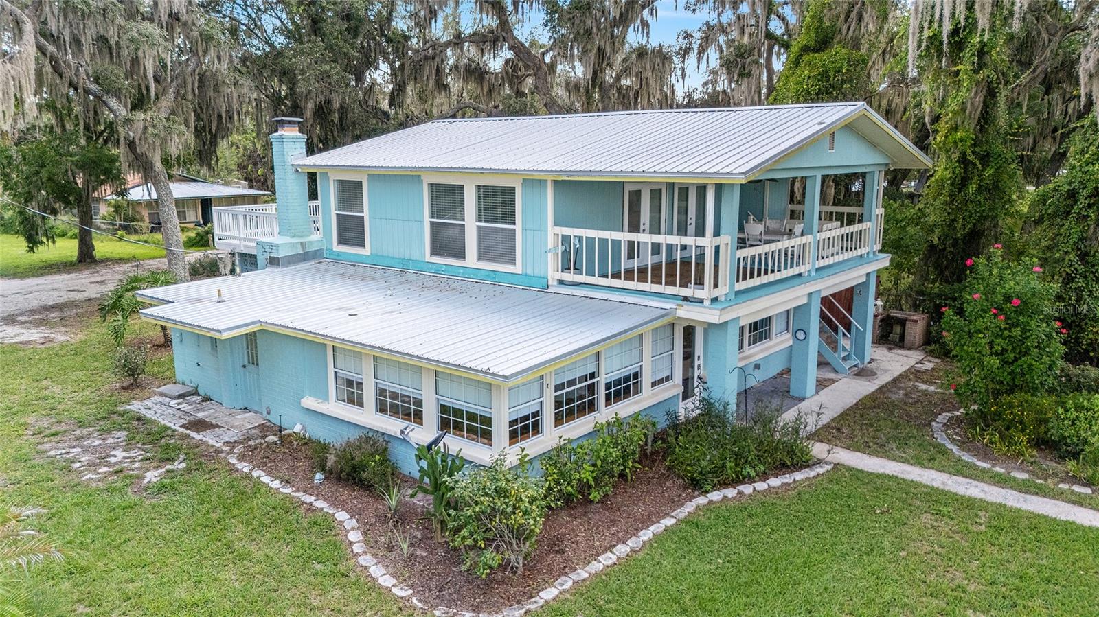 Dream no more—welcome to your own 1+ acre lakefront retreat on the pristine shores of private Pegram Lake, a 90-acre spring-fed gem. This residence, the very first home ever built on the lake, has been completely reimagined—renovated down to the studs. Every detail has been thoughtfully designed, blending luxury finishes with the natural beauty of Florida living. Here, life on the water is effortless—enjoy boating, jet skiing, fishing, or simply relaxing along your own shoreline. Across the lake, a private island adds to the charm of this natural oasis. The lake is also a sanctuary for Florida’s native wildlife; it’s not uncommon to see graceful sandhill cranes, herons, and geese migrating along the shoreline, creating a peaceful and picturesque backdrop. The grounds feature a lovely pollinator garden, perfect for cultivating your favorite plants or simply enjoying the serenity of the outdoors. The gourmet kitchen is a showstopper, boasting exotic granite countertops, custom cabinetry, custom farmhouse sink and a stone-accented fireplace. A spacious island provides bar seating, while the open dining area features a built-in butler’s cabinet—all overlooking breathtaking lake views. The spa-inspired main-level bath offers a glass shower and freestanding tub with barn-door entry. An enclosed Florida room under A/C flows seamlessly to the lakeside porch, while upstairs you’ll find three bedrooms, a second fully renovated bath, and even a second kitchen—making this home an ideal AirBnB or multi-generational retreat. Rental potential is outstanding, with nightly rates of $250–$300 or $1,500–$1,800 per week. This is more than a home—it’s a lifestyle, a sanctuary, and an investment opportunity all in one. Bring your family, friends, or guests and experience the rare beauty of Florida lakefront living.