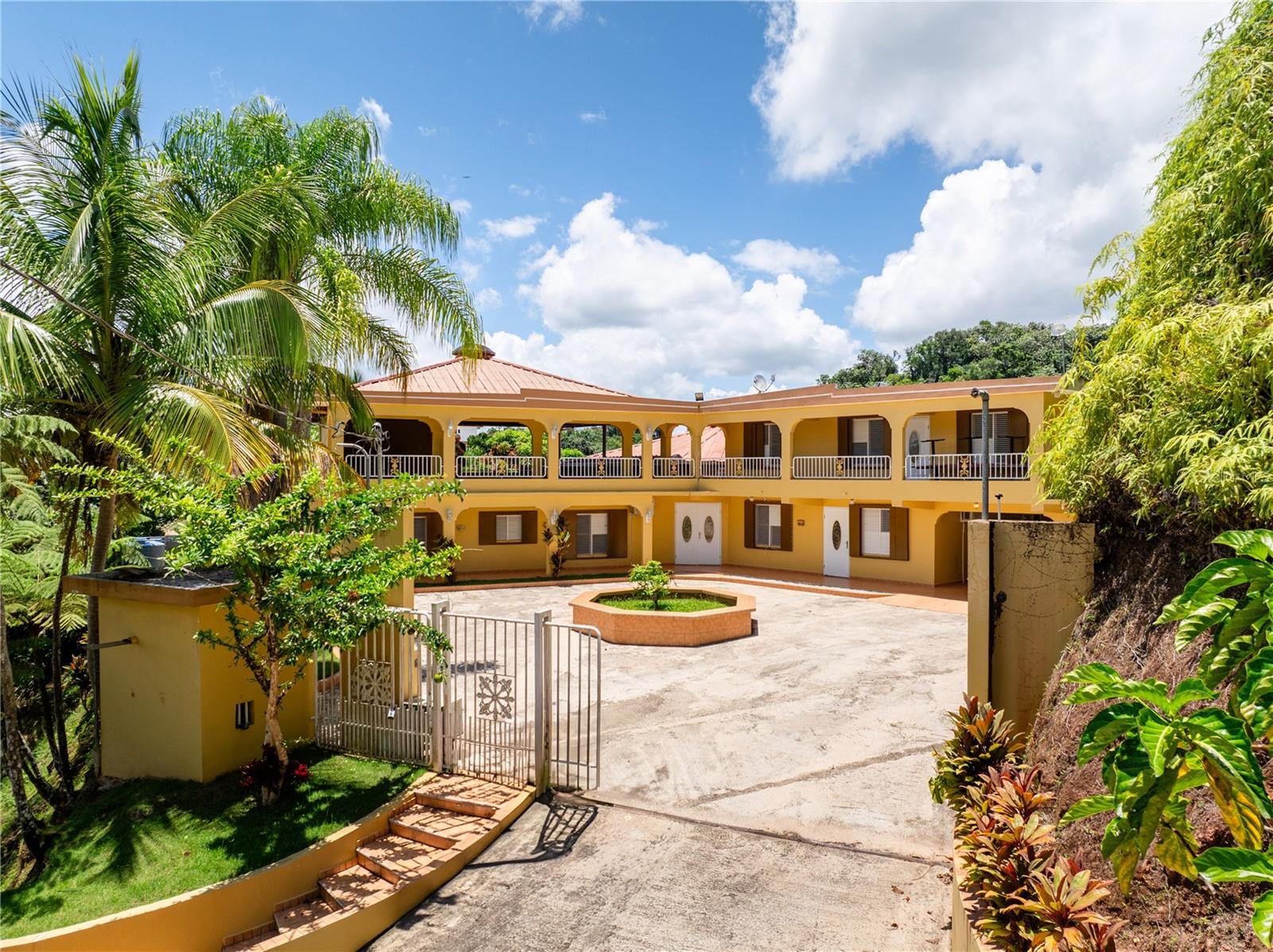 Set on a lush hillside in the mountains of Lares, Puerto Rico, this spacious property offers a unique layout and endless possibilities for customization. With 8 bedrooms, 6 full bathrooms, and 2 half baths spread across two levels, it provides generous space for residential or rental use. The interior features high vaulted ceilings with wood accents, an open living area, and a functional kitchen, while the exterior includes scenic mountain views, a wraparound balcony, and a rustic wooden structure known as "La Tiendita de Don Cando."
Whether you're seeking a peaceful residence, a guesthouse investment, or a private retreat surrounded by nature, this hidden gem in Lares delivers endless possibilities.