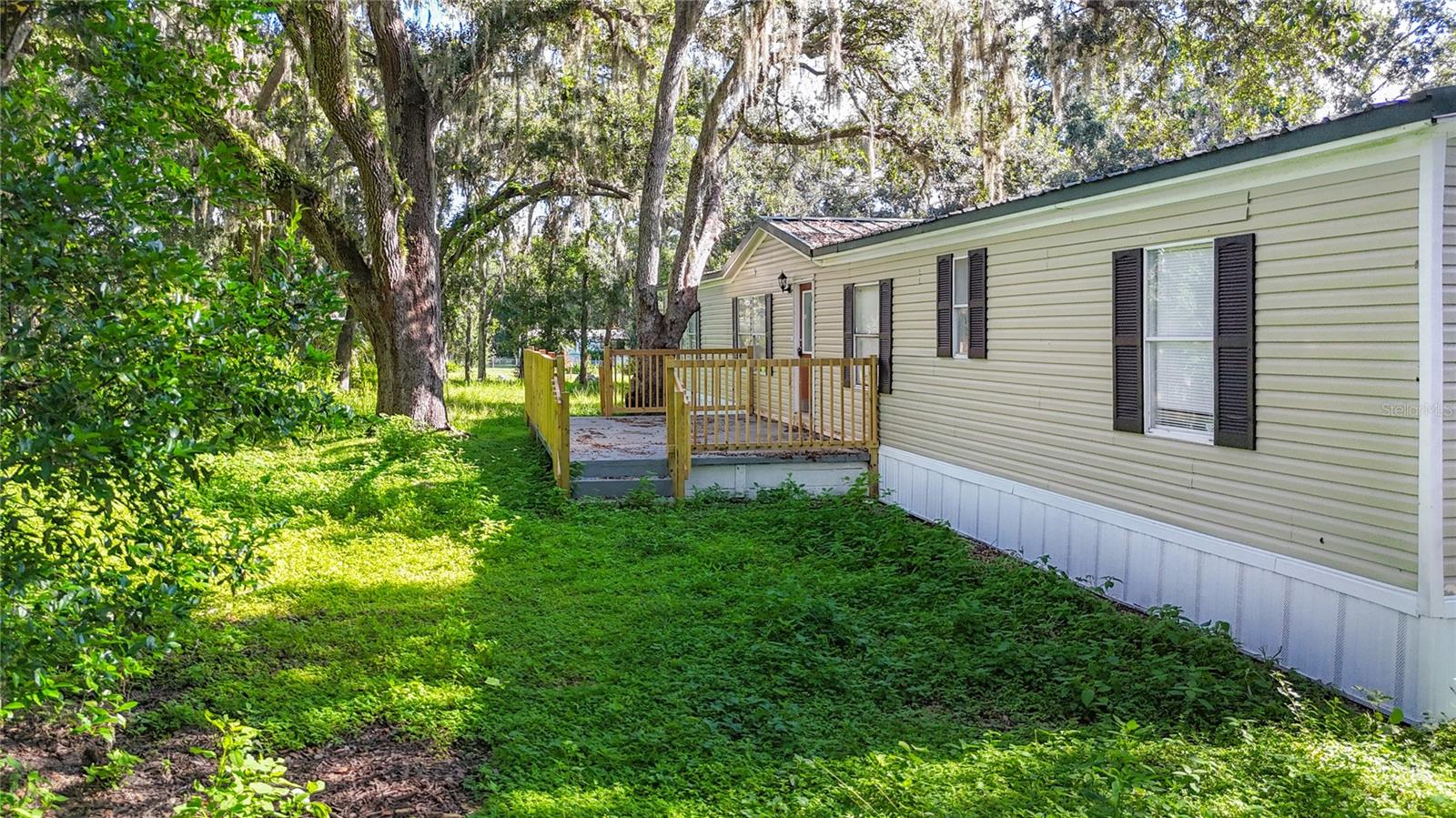 This amazing, fully renovated triple-wide manufactured home sits on just about 1 acre of land, in a convenient Riverview location. Featuring a metal roof, nicely wooded lot, and central AC, this home has room for the whole family. With 5 bedrooms, 3 bathrooms, a separate family room and living room, an eat-in kitchen, wood-burning fireplace, and two large patios (one in front and one out back), this home has plenty of room to spread out! The spacious, open floorplan features vaulted ceilings, a living room, dining area, plus a family room with a cozy wood-burning fireplace. Upgrades include quartz countertops throughout, new white shaker cabinetry throughout, new plumbing/ electrical fixtures, and stainless steel appliances. The master bedroom is a private oasis with a large walk-in closet and en-suite bathroom featuring a separate tub & shower, plus a dual sink vanity. Add to all this the amazing price, and this one is a must see!