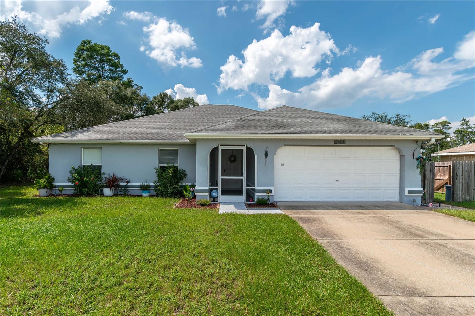 Nestled within the quiet community of Marion Oaks, this welcoming 3-bedroom, 2-bath home offers 1,695 sqft of well-designed living space and every day comfort. A screen-enclosed front entry and warm foyer set the tone as you step into the home, which features a thoughtful layout and lots of natural light throughout. The split-bedroom floor plan ensures privacy, while high and vaulted ceilings add a spacious, airy atmosphere. Tile flooring flows throughout the main living areas for easy upkeep, with plush carpeting in two of the three bedrooms. At the center of the home is the living room, which serves as a natural gathering place ideal for entertaining and relaxing. The kitchen is well-equipped with stainless steel appliances, a convenient breakfast bar, and an extra pantry for storage. A formal dining area with large windows overlooking the backyard and direct access to the patio, perfect for both casual meals and hosting. The primary bedroom includes a walk-in closet and a private en-suite bathroom, providing a quiet retreat at the end of the day. Outdoors, an oversized screen-enclosed patio with ceiling fan offers ample space for lounging or entertaining. The backyard is huge, running from the front of the home and providing ample space for recreation. An additional storage shed keeps lawn equipment nicely tucked away and tidy. Located within Marion Oaks, residents enjoy nearby shopping and dining options, plus quick access to State Route 200 and I-75. The community also features a center with meeting rooms, a library, recreation areas, and sports courts, with the Cross Florida Greenway just minutes away for added outdoor options. Whether you're putting down roots or simply looking for comfort and convenience, this home delivers value, space, and a lifestyle you can grow with.