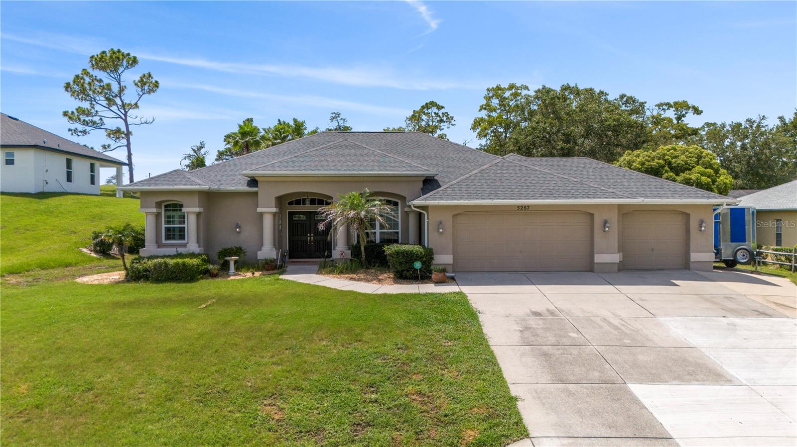 Welcome to your dream pool home, ideally located on the 4th fairway of Oak Hills Golf Course. Recent upgrades provide peace of mind, including: NEW 2025 ROOF, 2024 HVAC, NEW pool pump, NEW pool heater, NEWER windows, NEW refrigerator and NEWER motion lights in the back. Additional features include a spacious indoor laundry room with sink and generous storage throughout, in ground sprinklers, alarm system for safety, updated landscaping, three car garage, and paved spot on side of home for a trailer. From the moment you step inside, you’ll be captivated by the open great room featuring a tray ceiling, modern fan, and rich hardwood flooring. Sliding glass doors create a seamless connection to the expansive screened lanai—perfect for enjoying sweeping views of the heated pool and manicured fairway beyond. This thoughtfully designed split floor plan offers both elegance and functionality. The formal dining area adds a touch of sophistication, while the light-filled kitchen is a chef’s delight with a breakfast bar, abundant white cabinetry, pantry, and upgraded high-end stainless steel appliances. Sleek tile flooring complements the kitchen’s modern feel. Retreat to the spacious primary suite with its own tray ceiling and dual closets. The spa-inspired en-suite bath includes dual sinks, a garden tub, and a walk-in shower for ultimate relaxation. A convenient pool bath allows easy access to outdoor spaces without disrupting the flow of the home. Step outside to your private oasis, complete with a brick-paved pool deck, new LED-lit heated pool, and a newly fenced yard with a retaining wall. You'll love the peace and privacy. This exceptional home offers comfort, style, and resort-style living year-round. Don't miss the opportunity to make it yours.