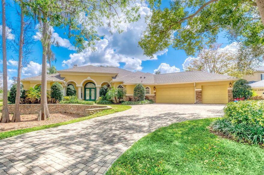 Welcome to 2983 Wentworth Way, Tarpon Springs, Florida! Impeccably maintained residence in the prestigious Gated Community of Wentworth. This impressive custom-built former model home, constructed in 2003, offers approximately 3,598 square feet of thoughtfully designed living space on a 0.45-acre newly fenced lot, featuring 4 spacious bedrooms and 3.5 modern baths, a private home office, and a bright, inviting bonus room currently used as a billiards room. The property also includes a roomy 3-car garage and a dedicated yoga/exercise room, providing a truly versatile layout. The home showcases outstanding curb appeal with lush, mature landscaping and a beautifully paved circular driveway. 
Upon entering the light-filled foyer, guests are greeted by views of the resort-style pool, complemented by high-end finishes such as a formal living room with stacked stone gas fireplace, travertine flooring, crown molding, and tray ceilings. The kitchen is a standout feature, equipped with granite countertops, a large center island, custom cabinetry, prep sink, refined backsplash, gas range, stainless steel appliances, and spacious counter seating. Enjoy lunches from the cozy nook overlooking the tranquil pool area with soothing waterfall sounds in the background.
The primary suite is a private retreat with a separate sitting area that offers direct access to the pool area. Other features include tray ceilings with custom detailing, newly added hardwood flooring and an oversized walk-in closet. The spa-like master bath includes dual vanities, a new soaking tub, and an updated step in shower. Three additional bedroom suites provide comfort and privacy, each with walk-in closets and ensuite baths (one with a convenient Jack-and-Jill setup).
Step outside to your private outdoor space—an expansive pavered lanai featuring a heated saltwater Pebble Tec pool, spill-over spa, cascading waterfall, and an newer screen enclosure. This resort-style area is ideal for both entertaining and relaxation, highlighted by a secluded cabana with a gas fireplace and waterfall features that create a tranquil setting. Located within a secure, 24-hour manned gated community, residents benefit from close proximity to the desirable East Lake corridor, offering convenient access to pristine Gulf beaches, top-rated shopping, medical facilities, airports, and all amenities associated with the Florida lifestyle.  New roof in August of 2024!