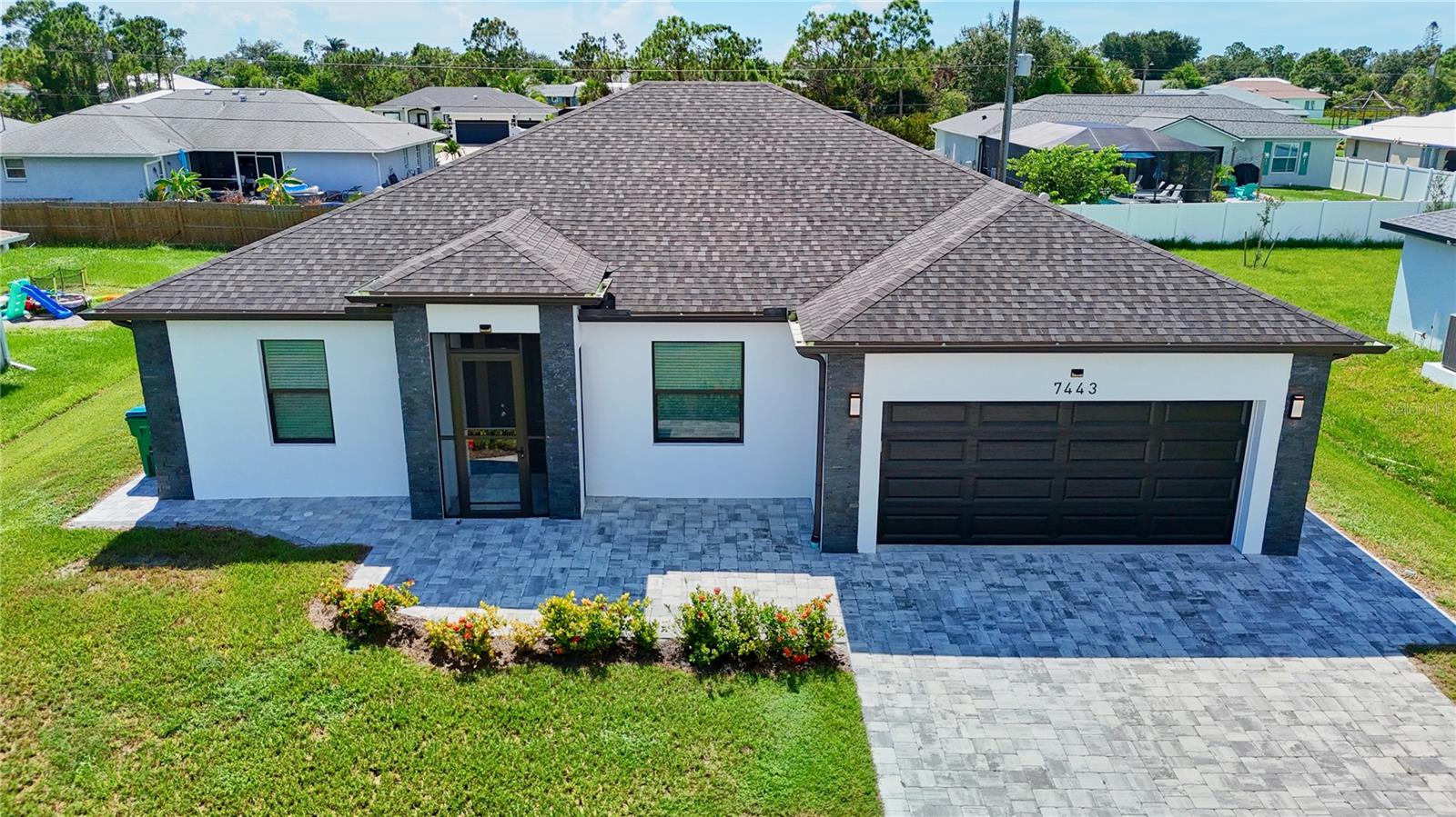 Designed for true multi-generational living, this custom-built 2021 Englewood home offers modern style, durability, and flexible spaces in a no-flood zone with zero storm damage. Built with hurricane-proof windows, a high-quality roof, and an insulated attic, it delivers peace of mind and energy efficiency.
The home features a private mother-in-law suite with its own bedroom, full bath with tub, and a complete second kitchen with coastal-inspired shaker cabinetry, marble counters, and full appliance package. A bonus room adds even more flexibility—perfect as a gym, office, or storage—with direct access to the screened, oversized lanai.
The main side offers a bright primary suite with walk-in closet and spa-style bath with marble-look tile to the ceiling, plus an additional bedroom. The living room flows into a modern kitchen with waterfall quartz counters, stainless steel appliances, a large pantry, and French doors opening to the oversized screened lanai—ideal for entertaining or relaxing.
Extras include a 2-car garage with washer/dryer and shelving, wide paver driveway, pavers around the entire home, screened front entry, and gutters. Just minutes from Manasota Beach and Boca Grande, this is a rare opportunity to enjoy Florida living with the comfort of multi-generational design.