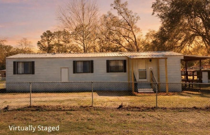 One or more photo(s) has been virtually staged. Adorable and affordable! This charming 2-bedroom, 1-bath home sits on a spacious 0.24-acre lot on a paved road in a convenient location. The property is fully fenced with chain link, offering security and room for pets, gardening, or outdoor enjoyment. Recent updates include fresh paint, updated fixtures, window treatments, ceiling fans, sinks, new skirting, a new water heater, and a brand-new drain field, making this home move-in ready. The durable metal roof adds peace of mind, and the workshop now has power, creating the perfect space for hobbies, storage, or a small workspace. Located just 15 minutes from schools, shopping, and everyday conveniences, and less than 30 minutes from Cedar Key, the Gulf, Shell Mound boat ramp, and the Lower Suwannee National Wildlife Refuge. Whether you're a first-time homebuyer, investor, or looking for affordable full-time Florida living, this property offers a great opportunity to enjoy the Nature Coast lifestyle.