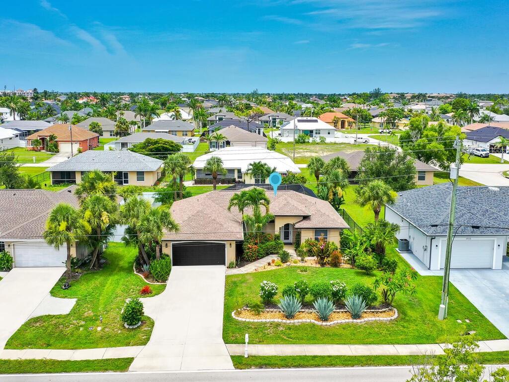 Pool home with AMAZING LANDSCAPING! Rare find in Cape Coral, this home's owner has spent endless hours & thousands of dollars on the gorgeous landscaping that surrounds the entire property- including a raised bed organic garden area. You will love the refreshing feel of the updated home from first step into the foyer- cathedral ceiling, tile flooring, almost wall-to-wall windows facing pool lanai, den/home office with glass door, custom sliding barn door on guest wing, great room design, updated kitchen with high-end appliances & cabinetry, spacious master bedroom with walk-in closet, laundry room w/ shelving, attached 2-car garage, and a huge screened pool lanai w/ covered sitting area. The accordion & electric shutters throughout offer peace of mind and can also function as sunshades in the lanai. Situated in the highly desired SW Cape Coral corridor, and just a short drive to the shopping & entertainment at Gulf Harbour and Tarpon Pointe. In addition, this home is perfectly located to have easy access to Veteran's Memorial Pkwy and Cape Coral Pkwy giving you easy access to community parks, library, boat ramps, and to Fort Myers/Pine Island/Punta Gorda!