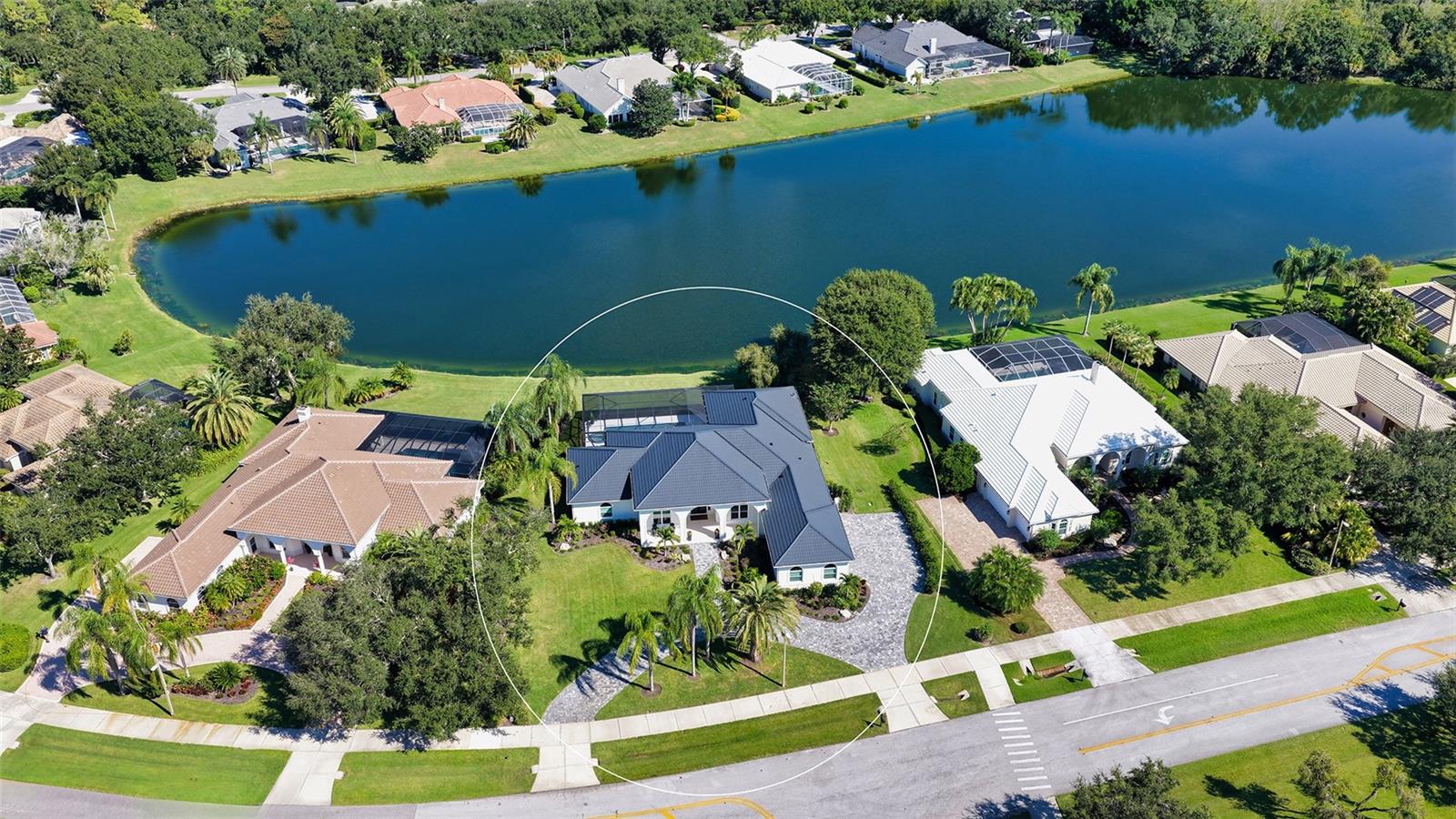 Refined Lakefront Luxury in Laurel Oak Estates!
Experience timeless elegance and exceptional craftsmanship in this custom-built John Karel residence located within the prestigious Laurel Oak Country Club. Privately positioned on more than half an acre with 108 feet of lake frontage, this 3,900-square-foot home captures serene water views from nearly every room and offers the perfect blend of sophistication and modern livability. Meticulously updated and enhanced throughout; every element has been elevated to today's highest standards.
A circular drive and manicured landscaping introduce the home’s welcoming architecture, while a double-door entry opens to expansive living spaces with luxury vinyl flooring, high ceilings, crown molding, and abundant natural light. The open floor plan creates seamless flow between the great room, dining area, and the well-appointed kitchen—ideal for entertaining or casual gatherings.
The chef’s kitchen is equipped with custom European cabinetry, a large center island, stone counters, breakfast bar, Bosch Benchmark Series stainless appliances including built-in oven and gas range, farmhouse sink, and newly designed walk-in pantry. The adjacent family room features pocketing sliding glass doors that open to the covered lanai, blurring the line between indoor and outdoor living.
The primary suite serves as a private retreat with tranquil lake views, a generous walk-in closet with custom shelving system, and spa-inspired bath featuring Brizo Black Onyx Chrome finishes, walk-in shower with bench seating, and private water closet. Three additional bedrooms, including an en-suite guest room and a Jack-and-Jill configuration, provide comfort for family and guests alike. A dedicated office enhances functionality for remote work or quiet study.
Step outside to the panoramic newly screened lanai where a freshly resurfaced heated pool, spa, and outdoor kitchen invite year-round relaxation. The covered patio is ideal for al fresco dining, while the full lake view delivers a peaceful backdrop. The extensive list of recent improvements include a new metal roof, impact windows and doors, electric hurricane screens on entire lanai, resurfaced pool and spa, whole-house generator, 500-gallon buried propane tank, two new A/C units with ultra violet technology, tankless water heater, and water filtration system. All new window coverings, light fixtures and solid wood interior doors. All bathrooms have been updated and include Amorho touch mirrors. New driveway and walkway pavers and new irrigation system plus entire yard newly landscaped. Take comfort knowing this is a like-new home and ready for your immediate enjoyment.
Residents of Laurel Oak Estates enjoy a secure, guard-gated setting with private roads, tree-lined streets, and the option to join Laurel Oak Country Club, featuring two championship golf courses, tennis and pickleball, a resort-style pool, and fine dining. The community’s convenient location near I-75, UTC Mall, and Nathan Benderson Park offers quick access to Sarasota’s renowned beaches, top-rated schools, and vibrant downtown arts scene.
This exceptional lakefront residence combines classic architectural style with a modern open layout, offering an unparalleled lifestyle in one of Sarasota’s most desirable golf and country club communities.