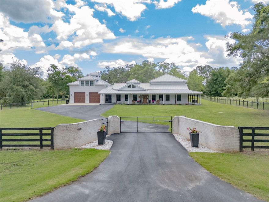 PRICE IMPROVEMENT!! POSSIBLE OWNER FINANCING, CALL FOR DETAILS. Welcome to a truly one-of-a-kind country estate—the custom builder’s own home, where every detail was designed with intention and elegance.

Tucked behind a gated entrance on 2 fully fenced acres, this spectacular 6-bedroom, 5.5-bath residence offers the perfect blend of luxury and comfort. From the moment you step inside, you're greeted by soaring ceilings with sky high windows that flood the home with natural light, an expansive open floor plan, and a sense of space that flows effortlessly into the massive screened-in porch—ideal for morning coffee or sunset gatherings by the resort-style pool. 

The first floor features two spacious en suite bedrooms, making it perfect for multigenerational living or guests. Upstairs, you’ll find three more bedrooms—or two and a flex room with a striking round wall of windows that captures stunning views of the oak-dotted backyard.

A true standout is the studio apartment above the garage—complete with its own private screened-in balcony and separate entrance, perfect for visitors, in-laws, or even an income-producing rental. There's also another private screened porch off the upstairs bedroom, adding to the serene, retreat-like feel.

Every inch of this home showcases top-of-the-line upscale finishes, from the flooring to the fixtures. The oversized garage is equally impressive, featuring a half bath and a pull-through design for added convenience.

And the location? It’s the best of both worlds—just outside the city limits of charming Williston, on a peaceful country road shared with Stonehedge, one of North Central Florida’s most prestigious equestrian farms. You're only 17 miles to Gainesville, 22 to Ocala, and just 21 miles to the World Equestrian Center.

This is more than a home—it's a lifestyle. Come see it for yourself.