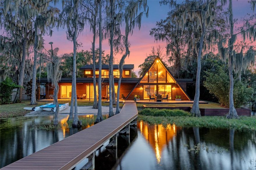 BACK on the Market! Butler Chain of Lakes Vintage A-Frame - Reimagined! Perhaps one of the most distinctive styles of modern architecture, this One-of-a-Kind, custom A-Frame home is like no other in the area. This beauty is located on the South shore of Lake Tibet on approximately .75 acres, with 100 feet of lakefront, including a sandy beach, seawall, dock, and boathouse. The home was originally a 1966 A-Frame that has been reinvigorated into a modern, mid-century structure that is light-filled and imbued with drama. Painstakingly crafted into its current form using high-quality materials, the home is beautifully rustic yet modern. Soaring wood ceilings, wood & tile flooring, a custom kitchen, and an onyx candle wall are just the beginning of the special features that make this home unique, along with a showpiece Iron Shop sculptural spiral staircase leading up to an intimate loft area. Every room in the home has breathtaking lakefront views facing North through large windows and glass doors. On the main level is the custom Kitchen, Living Room, Dining Room, Breakfast Nook, Laundry Room, and Powder Bath, plus two comfortable Guest Bedrooms with lakefront views which share a Full Bath. The Primary Suite provides a retreat that you'll love, with high tongue & groove cedar wood vaulted ceilings, a large walk-in closet with a custom built-in closet system, and a striking bath with a steam shower. The Primary Suite offers lake views not only from the bedroom & bathroom but also from a large walk-out balcony, where you'll want to linger over your morning coffee or happy hour cocktails. A car lover's delight is what you'll find in this home's incredible 1,200 sq. ft. garage that has 3 bays and stacked space for additional vehicles or equipment. The garage also features unique industrial vehicular carpet flooring, a workbench, and tons of storage for any hobby. As for the home's exterior, a new extended dock with beautiful composite decking, and a covered boat house with lift, electric, & water will keep you loving the Butler Chain of Lakes lifestyle. An expansive, lakeside covered patio overlooking the lake is accessible from all ground-level lakeside rooms. The property has lush landscaping that adds significant privacy on both sides of the home, an extensive paver driveway with a 25 x 25 parking area, and a specific boat trailer storage area. Back inside, you'll find an 18 ft. long wall of storage closets with organizational shelving, perfect for all your storage needs. Other special property features include an updated septic system, dual filtration water system with Pentair soft water, and no homeowner’s association. Seller is leaving all furnishings, TVs and electronics, Nautique Ski boat., and Hobe Cat sailboat, excluding personal property, artwork (cars and tools in garage). This property is like none other!