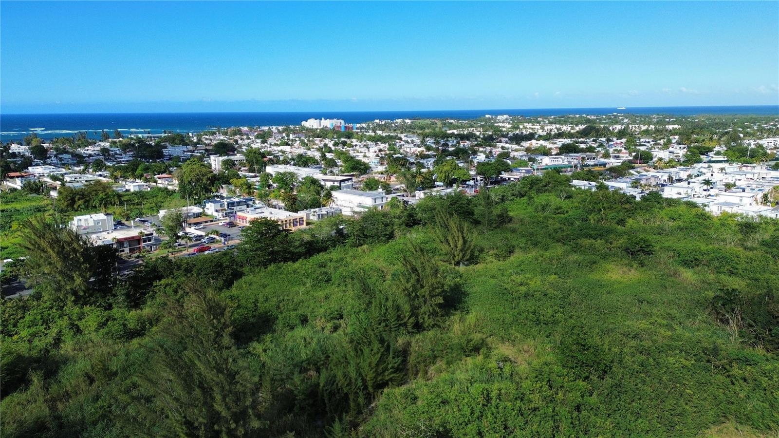 This 6.8909-cuerda parcel (approximately 6.7 acres) is positioned in one of Dorado’s most active areas, directly adjacent to Plaza Dorada Shopping Center and just a 10-minute drive from Dorado Beach. Zoned CT-L (Comercial TurÃstico Liviano), the site allows for a range of low-impact commercial and tourism uses including boutique hotels, branded short-term rental communities, wellness or medical tourism centers, and neighborhood-scale retail or dining. Its location, bordered by established residential neighborhoods like Quintas de Dorado, Dorado del Mar, and Paseo del Mar, offers consistent local activity with proximity to one of Puerto Rico’s most exclusive resort destinations.
Well-suited for developers or investment groups seeking a strategic position in the growing Dorado market, the parcel combines rare scale with zoning flexibility. Puerto Rico’s current incentive programs support tourism-related investment and commercial development, while its status as a U.S. jurisdiction offers distinct tax and operational advantages. One of the few remaining parcels of its kind in the area, this site offers a solid foundation for projects that align with the long-term growth of the region.