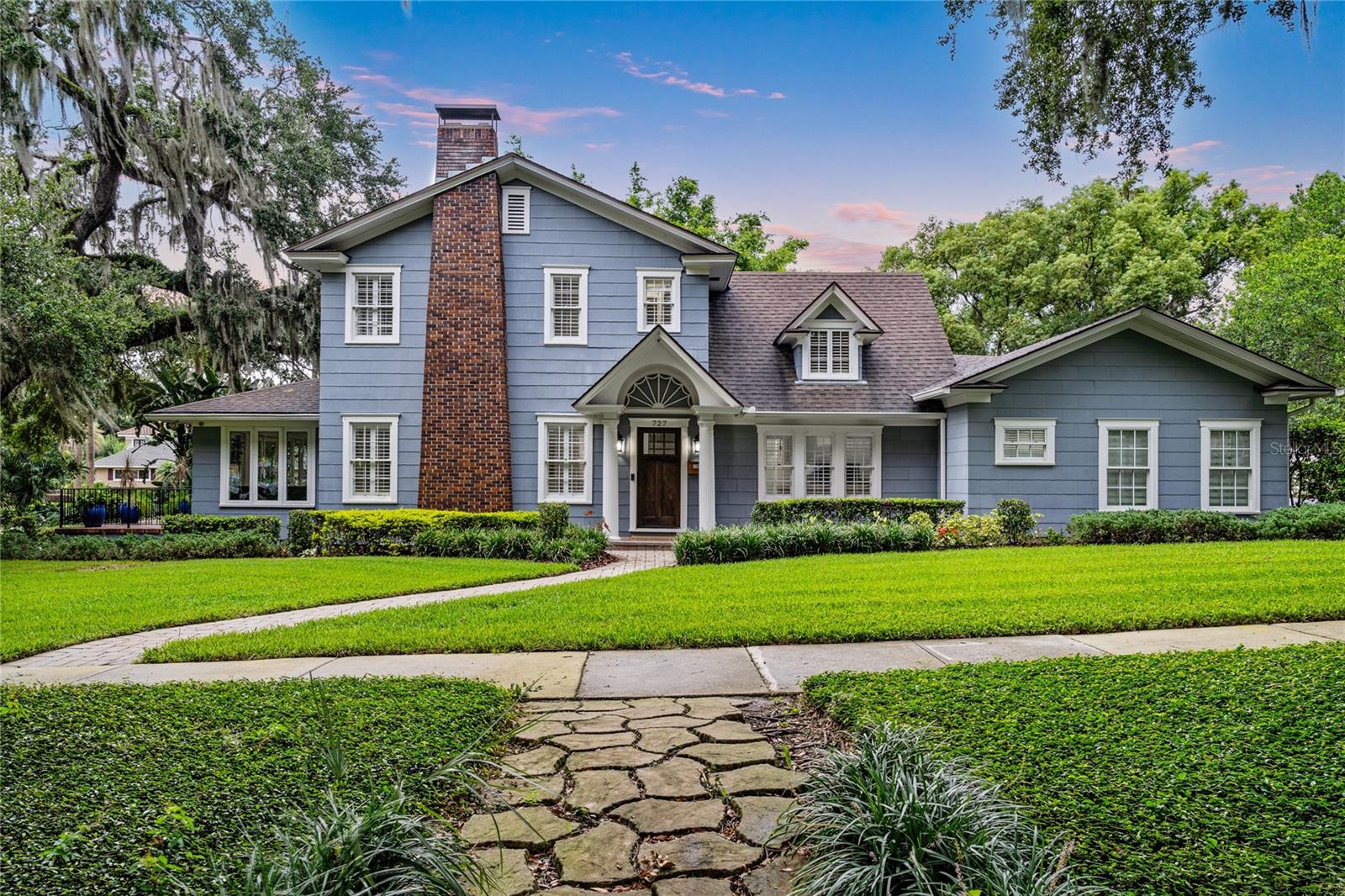 WELCOME TO THE CENTENNIAL HOUSE. Constructed in 1925, this magnificent 100-year-old estate received an authentic renovation reflecting the current conveniences of today’s modern living. The charming exterior detail inspires the imagination of what lies within the front entry door. A renovation / expansion exceeding $500,000 was completed by the home’s current owner, demonstrating the stewardship this home has received during its existence. At the heart of the home, a re-designed and updated kitchen includes a gas WOLF RANGE and SUB-ZERO refrigerator and wine fridge. Stately navy cabinetry and smooth grey granite wrap an apron-front stainless-steel sink. Counter-to-ceiling herringbone tile backsplash, overhead stainless hood and clear glass-front cabinetry inserts will inspire you in this showcase kitchen environment. Engineered wide-plank hardwood flooring extends throughout the entire home. Marble hearth anchors the brick-wrapped, wood burning fireplace beneath exquisite dental crown molding in the formal living room. First-floor, oversized primary bedroom, privately situated in the rear of the home, offers direct access to the side deck via an exterior door. Primary bathroom remodel includes a free-standing deep soaking tub, seamless glass shower including an overhead rain shower, all wrapped in timeless tile. An additional first-floor bedroom offers an attached en suite bathroom and two closets. Perfectly situated as a nursery, office, or generational suite. Westerly facing window-wrapped Solarium offers magnificent views of Park Lake, directly across the brick paved streets within the neighborhood. Upstairs living area includes three sleeping quarters and two fully renovated baths, both of which are en suite to a bedroom. Oversized car parking area has a two-car detached garage and outside paver courtyard for your entire car collection. Overhead café lighting creates an enchanting evening ambiance. THE CENTENNIAL HOUSE is mere blocks from top-rated Lake Highland Preparatory School (PK-12)! FOUR-POINT FEATURES: Air Conditioning (2025 / 2017 / 2015) – Hot Water Heaters (2010) -- Roof (2017) -- Replumbing (2017) – Electrical Panels (Square D / Siemens).