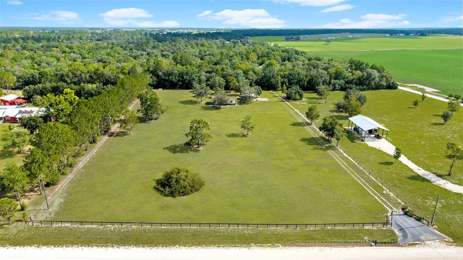 Equestrian Charm in Triple Crown Farms – 5 Beautiful Acres in a Horse-Friendly Community
Welcome to Triple Crown Farms, a peaceful and picturesque equine community nestled in the countryside of Levy County. This 5-acre property offers the ideal blend of quiet country living and accessibility to Florida’s premier horse venues and trail systems. Whether you're an equestrian enthusiast or simply seeking a more relaxed lifestyle in a friendly neighborhood, this property delivers comfort, space, and convenience.
As you enter through the electric gated entrance, you’ll immediately notice the expansive green grass and mature landscaping that offer both beauty and function—perfect for gardening, outdoor enjoyment, or future horse improvements. The gravel driveway leads you to a detached 24x26 two-car garage and an 18x21 carport, ideal for your RV, horse trailer, or additional parking. A matching walkway leads to the inviting back porch entrance, offering seamless access into the home.
Inside, you’re welcomed by a spacious laundry and mudroom area with plenty of storage, conveniently located next to the master bathroom. The kitchen is a standout feature, boasting custom cabinetry that extends to the ceiling, upgraded vinyl plank flooring, newer stainless and black appliances, and a large window over the sink that fills the space with natural light. The open-concept design flows into the dining area and living room, where large windows, crown molding, and a built-in TV/bookcase continue the home’s bright and inviting feel.
On one side of the home, you’ll find two comfortable guest bedrooms and a full bathroom. The east side is home to the spacious master suite, complete with a walk-in closet and an en-suite bathroom featuring dual sinks and more custom cabinetry. This home offers thoughtful design and functionality throughout.
Outside, the property continues to impress with a 10x12 workshop equipped with electricity, a designated garden area, and a full water system. The entire 5 acres are enclosed with perimeter fencing, making it ready for pets or future equestrian use. While there are no designated pastures, the lush grass and open layout provide endless potential for horses, small livestock, or simply enjoying a wide-open space.
Triple Crown Farms is a quiet, horse-friendly neighborhood where it’s common to see neighbors riding horseback, cruising in buggies, or walking their dogs along the peaceful roads. It’s the kind of place where community and tranquility go hand in hand, and it’s all within reach of the best amenities for horse lovers and outdoor enthusiasts.
Located just six miles from the Goethe State Forest, you’ll have access to miles of riding trails and scenic overnight camping options. The property is also only 16 miles from the HITS Showgrounds, 23 miles from the World Equestrian Center in Ocala, and less than 30 miles to Crystal River for boating, fishing, and exploring Florida’s Gulf Coast. The charming towns of Williston and Dunnellon are each under 20 minutes away, offering small-town charm and essential conveniences, while downtown Ocala is just 27 miles to the east.
Whether you're an equestrian looking to create your dream setup or someone simply seeking peace, space, and beauty in a supportive rural community, this property in Triple Crown Farms is ready to welcome you home.